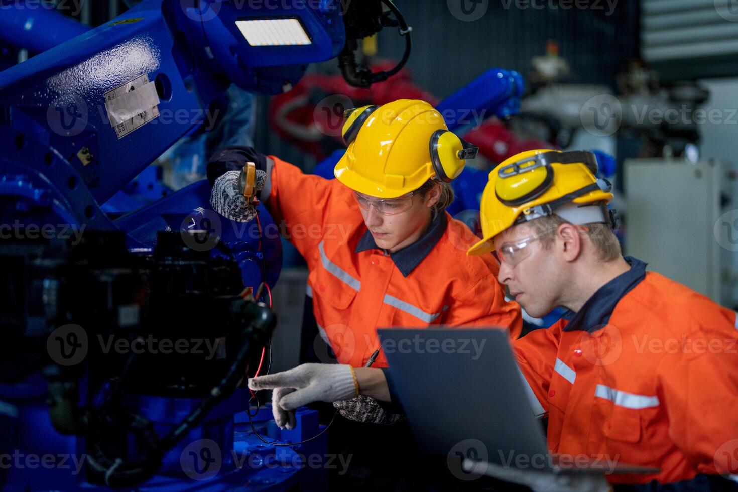 male engineer workers maintenance automatic robotic arm machine in a factory. worker checking and repairing automatic robot hand machine. technician worker check for repair factory machine. photo