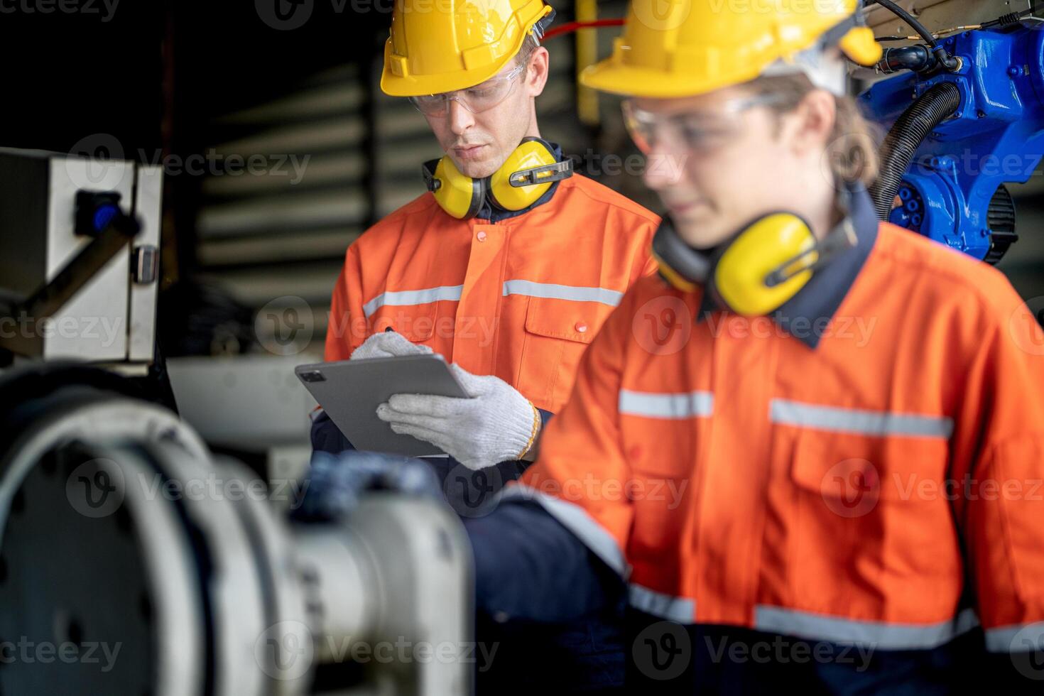 male engineer workers maintenance automatic robotic arm machine in a factory. worker checking and repairing automatic robot hand machine. technician worker check for repair factory machine. photo