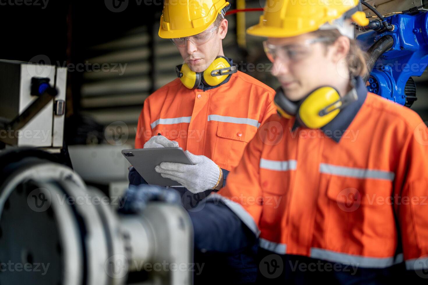 male engineer workers maintenance automatic robotic arm machine in a factory. worker checking and repairing automatic robot hand machine. technician worker check for repair factory machine. photo