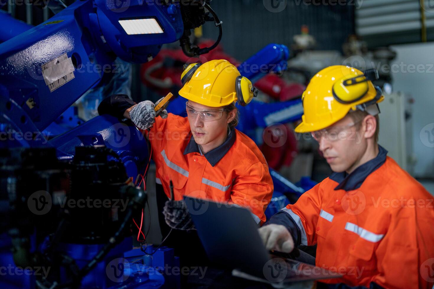 male engineer workers maintenance automatic robotic arm machine in a factory. worker checking and repairing automatic robot hand machine. technician worker check for repair factory machine. photo