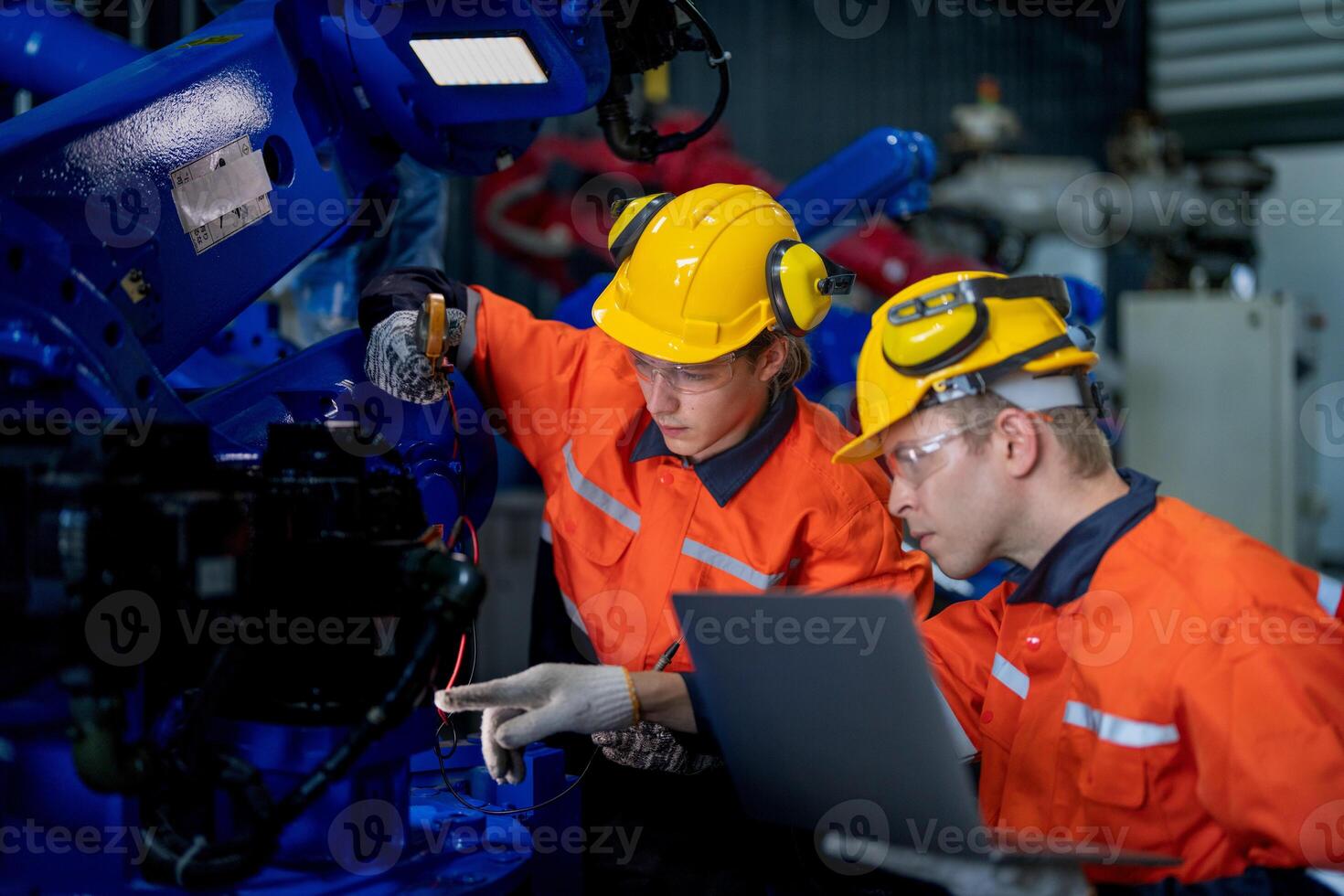 male engineer workers maintenance automatic robotic arm machine in a factory. worker checking and repairing automatic robot hand machine. technician worker check for repair factory machine. photo
