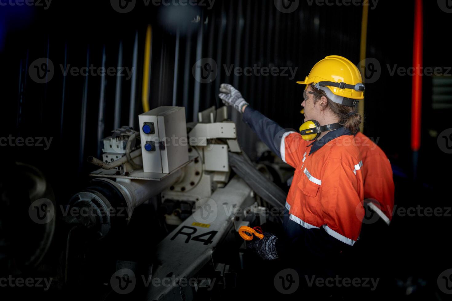 Engineer man checking the status of machine and used wrench to screw some part of equipment at CNC factory. Worker wearing safety glasses and helmet. Maintenance and repairing concept. photo