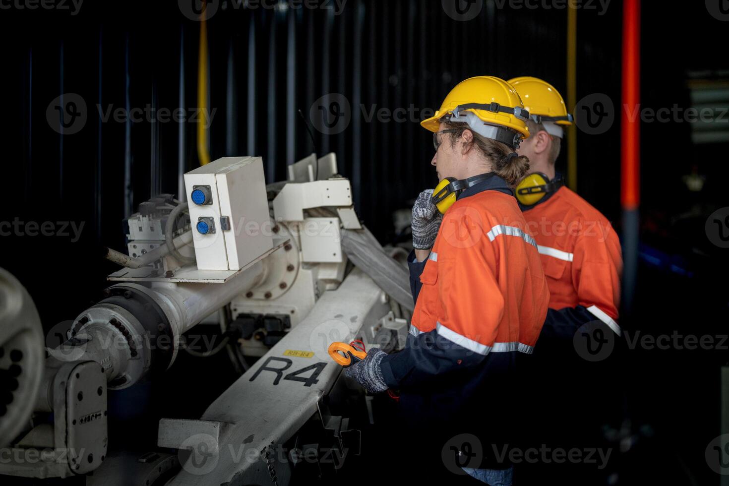 male engineer workers maintenance automatic robotic arm machine in a factory. worker checking and repairing automatic robot hand machine. technician worker check for repair factory machine. photo