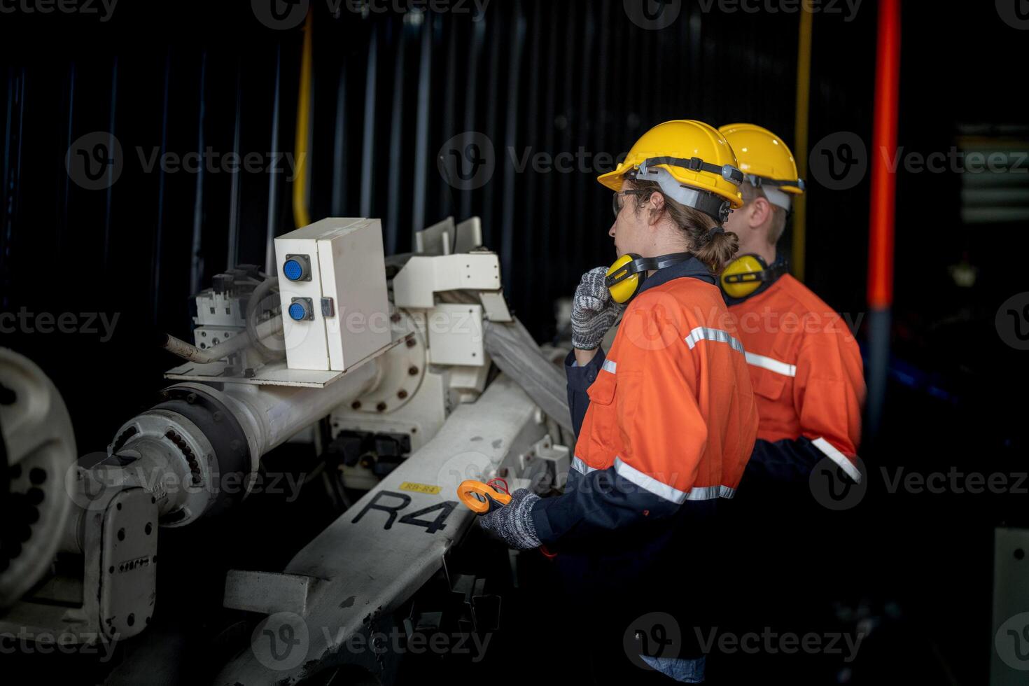 male engineer workers maintenance automatic robotic arm machine in a factory. worker checking and repairing automatic robot hand machine. technician worker check for repair factory machine. photo