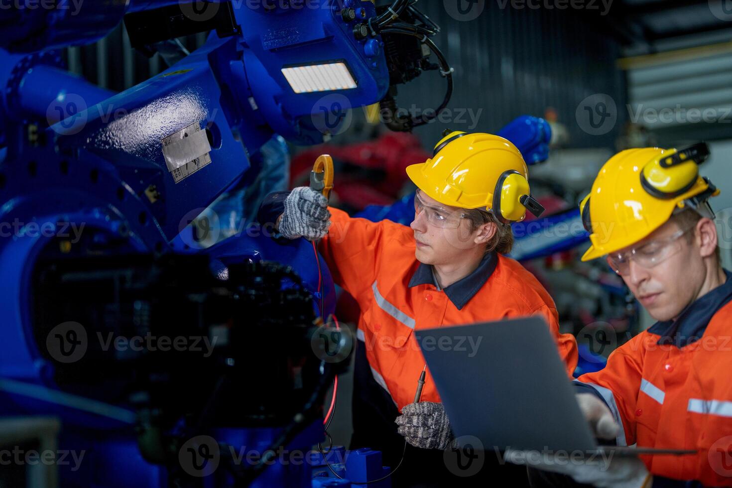 male engineer workers maintenance automatic robotic arm machine in a factory. worker checking and repairing automatic robot hand machine. technician worker check for repair factory machine. photo