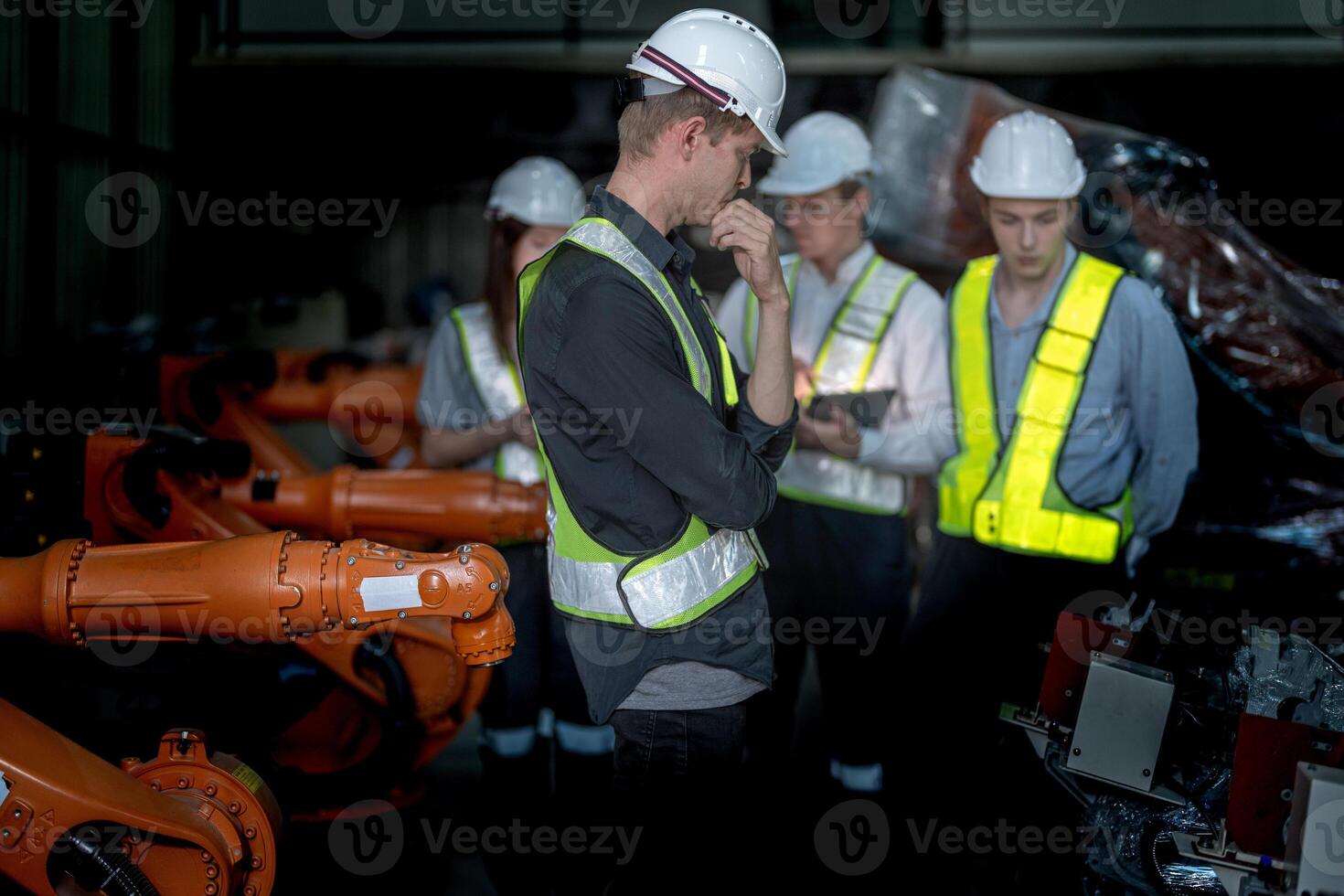 Sales manager and factory owner in suits negotiating selling robots used in the factory. Business engineers meeting and checking new machine robot. Workers walking at warehouse welding machine. photo