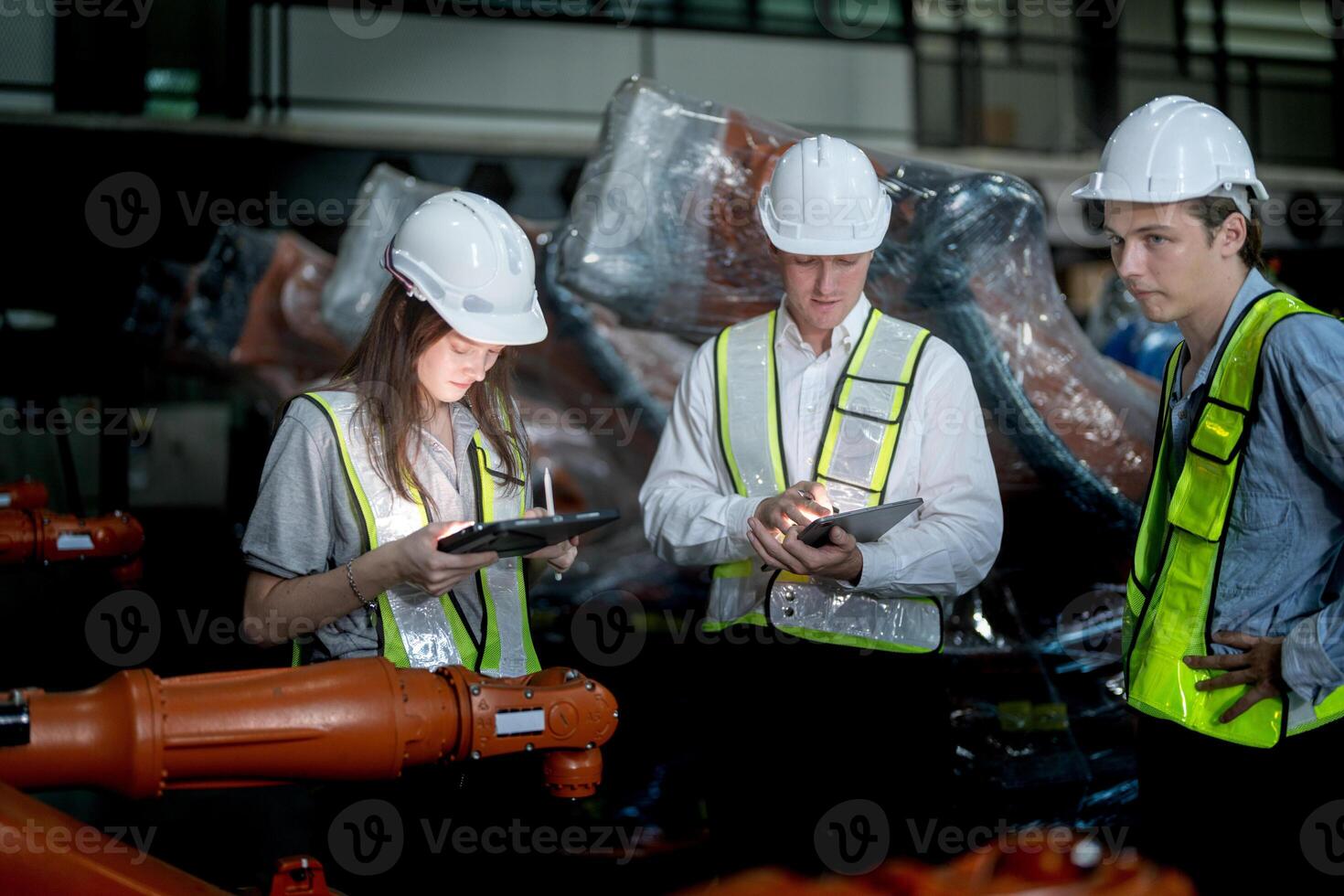 Sales manager and factory owner in suits negotiating selling robots used in the factory. Business engineers meeting and checking new machine robot. Workers walking at warehouse welding machine. photo