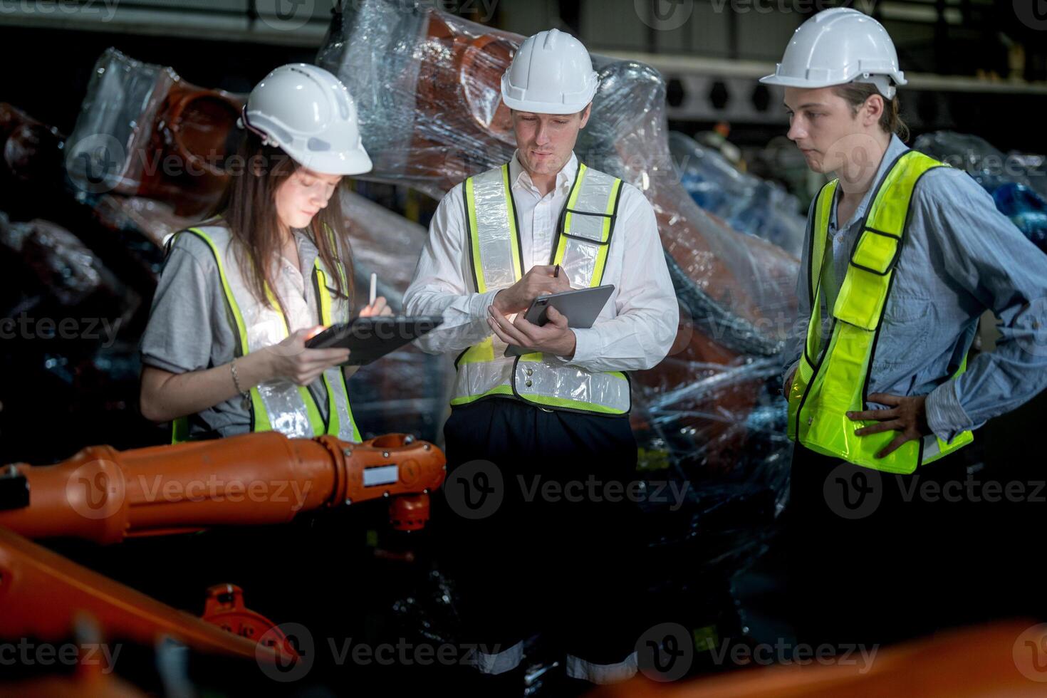 Sales manager and factory owner in suits negotiating selling robots used in the factory. Business engineers meeting and checking new machine robot. Workers walking at warehouse welding machine. photo