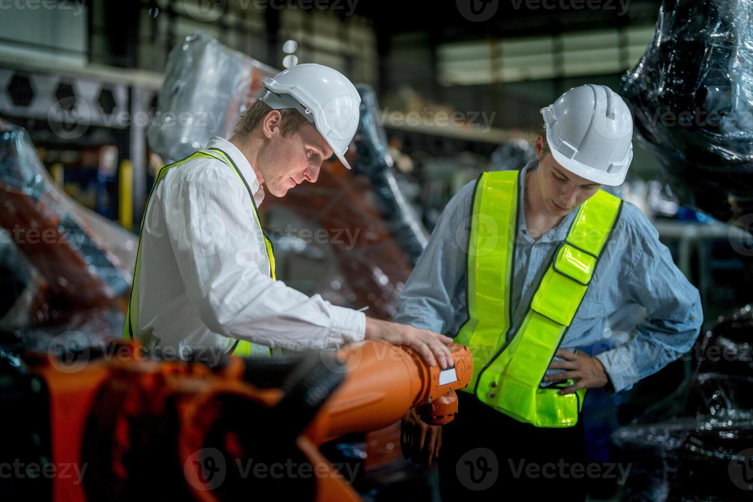 Business engineers meeting and checking new machine robot. Workers walking at warehouse industry welding machine. business negotiation concepts and technology. women Using smart Tablet to present man. photo