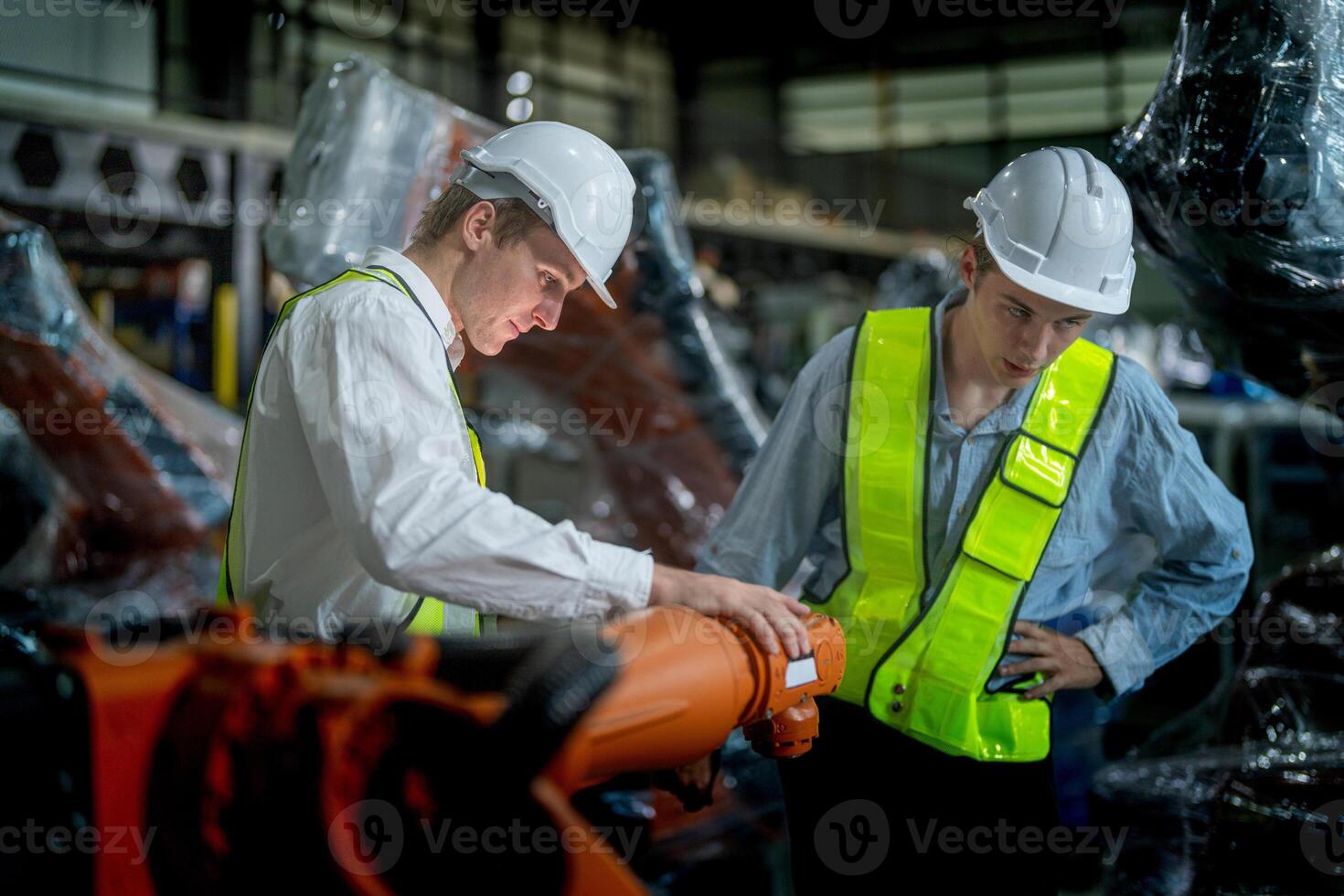 Business engineers meeting and checking new machine robot. Workers walking at warehouse industry welding machine. business negotiation concepts and technology. women Using smart Tablet to present man. photo