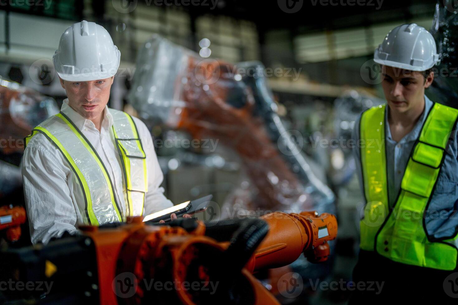 Business engineers meeting and checking new machine robot. Workers walking at warehouse industry welding machine. business negotiation concepts and technology. women Using smart Tablet to present man. photo