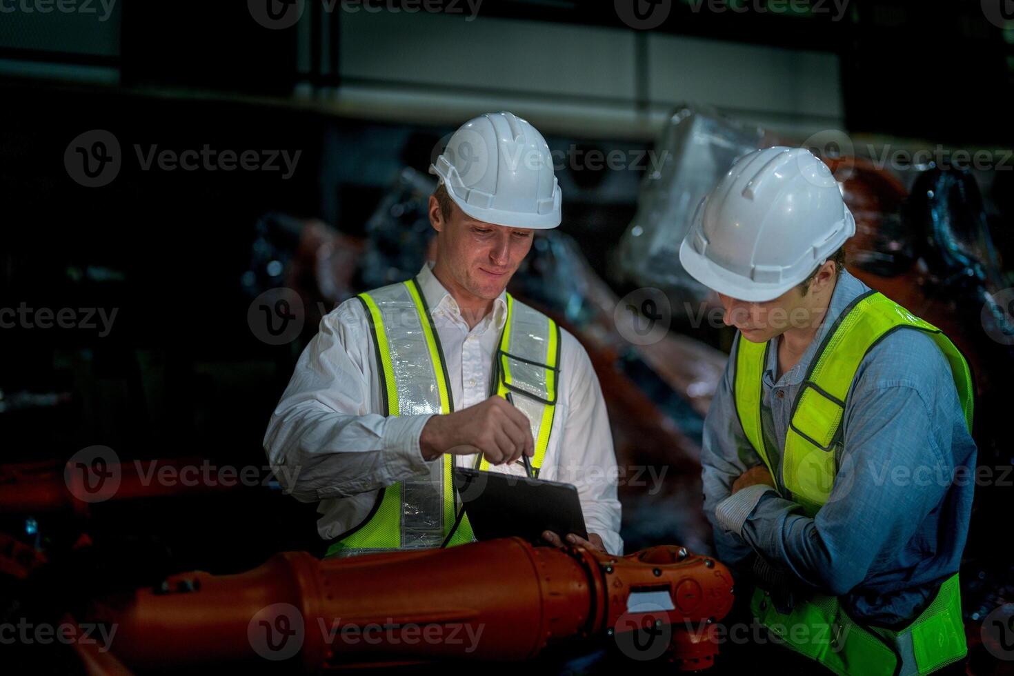 Business engineers meeting and checking new machine robot. Workers walking at warehouse industry welding machine. business negotiation concepts and technology. women Using smart Tablet to present man. photo