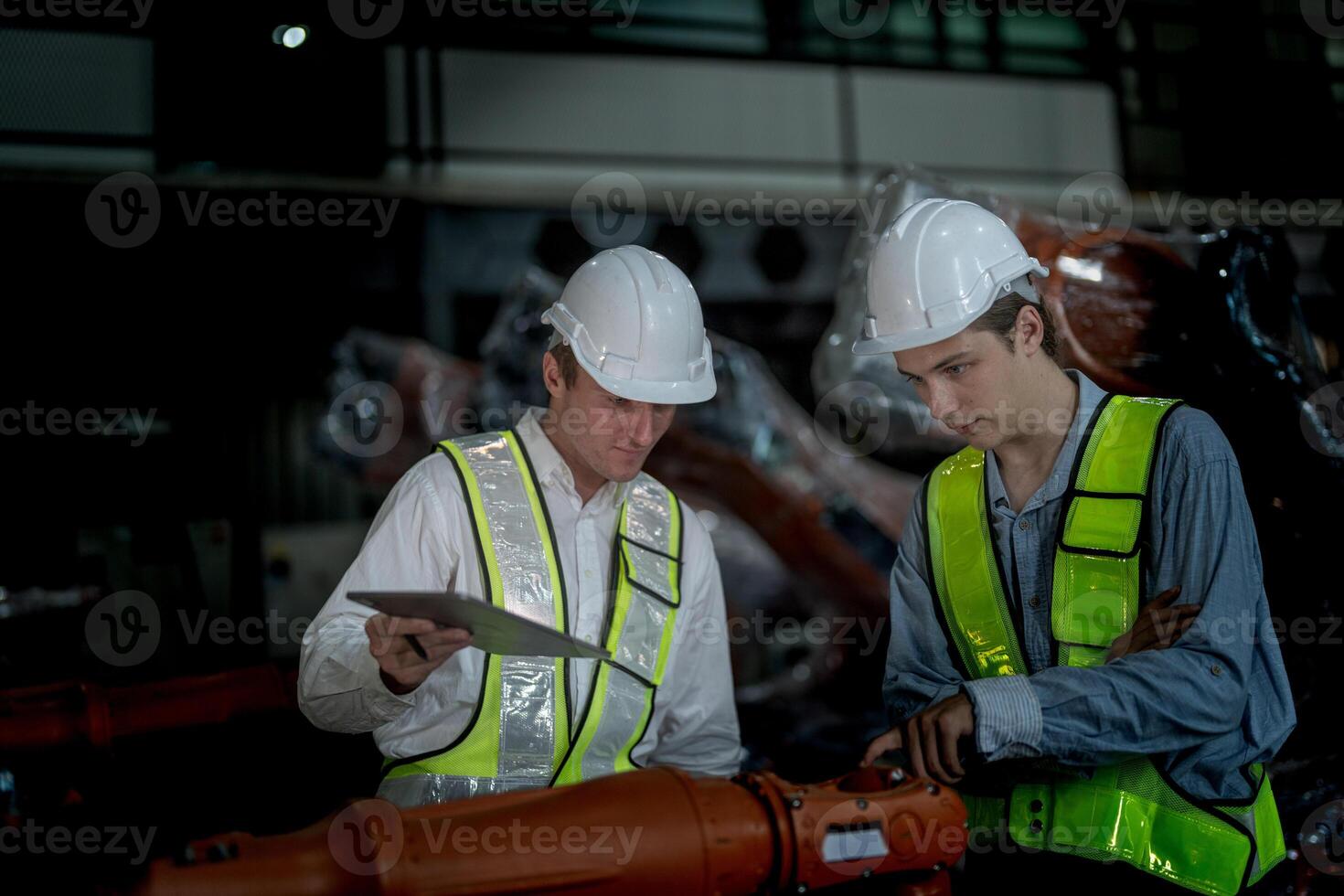 ventas gerente y fábrica propietario en trajes negociando de venta robots usado en el fábrica. negocio ingenieros reunión y comprobación nuevo máquina robot. trabajadores caminando a almacén soldadura máquina. foto