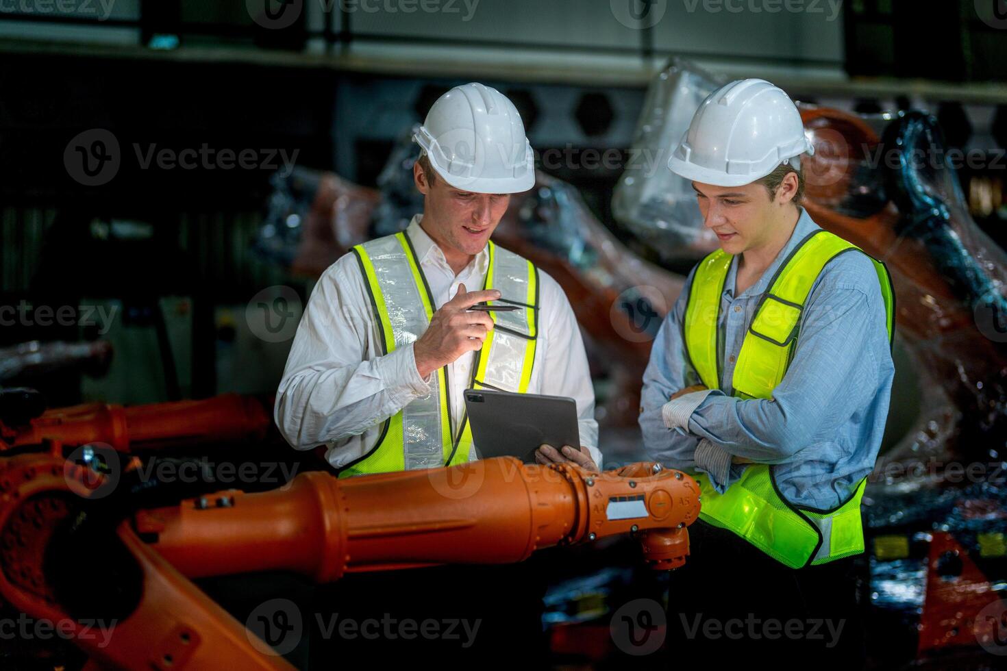 Business engineers meeting and checking new machine robot. Workers walking at warehouse industry welding machine. business negotiation concepts and technology. women Using smart Tablet to present man. photo