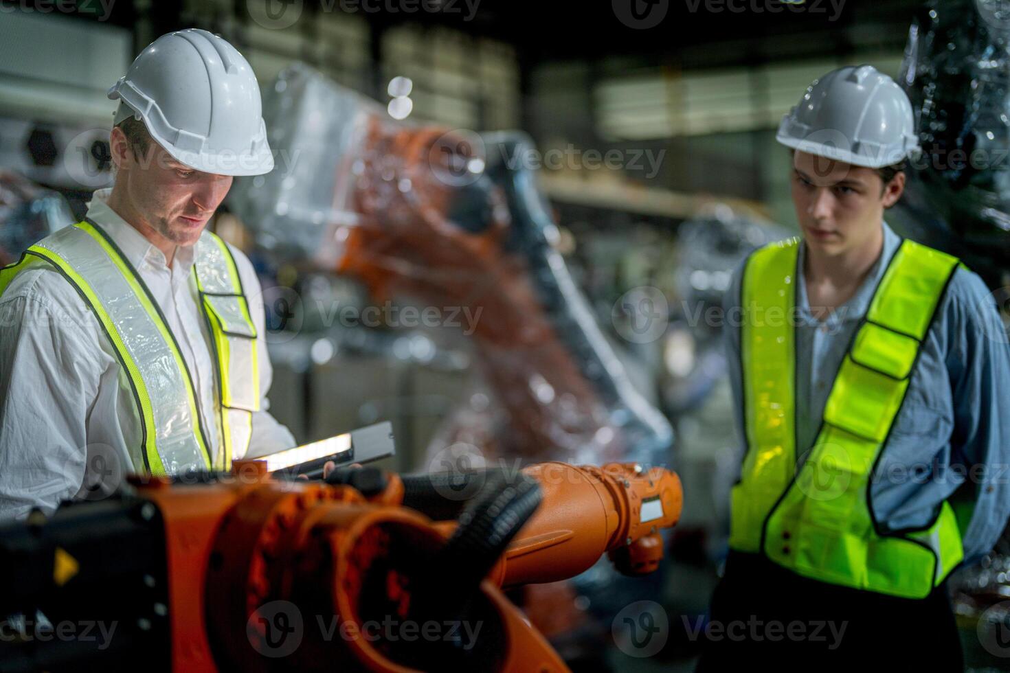 Sales manager and factory owner in suits negotiating selling robots used in the factory. Business engineers meeting and checking new machine robot. Workers walking at warehouse welding machine. photo