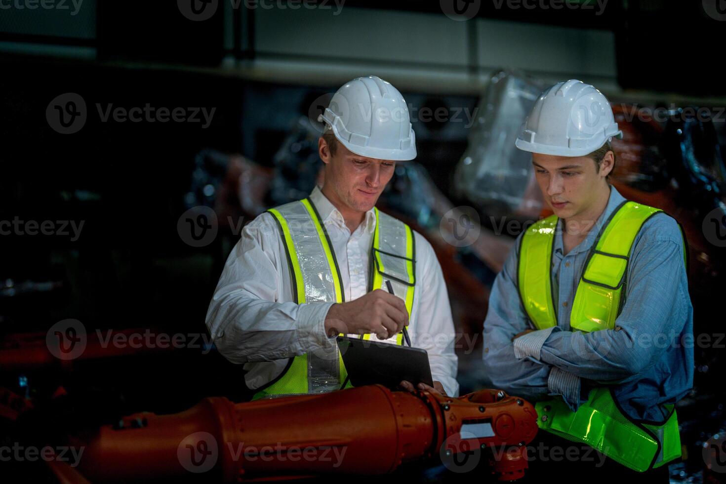 Business engineers meeting and checking new machine robot. Workers walking at warehouse industry welding machine. business negotiation concepts and technology. women Using smart Tablet to present man. photo