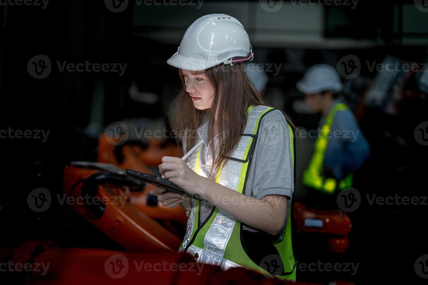 Business engineers meeting and checking new machine robot. Workers walking at warehouse industry welding machine. business negotiation concepts and technology. women Using smart Tablet to present man. photo