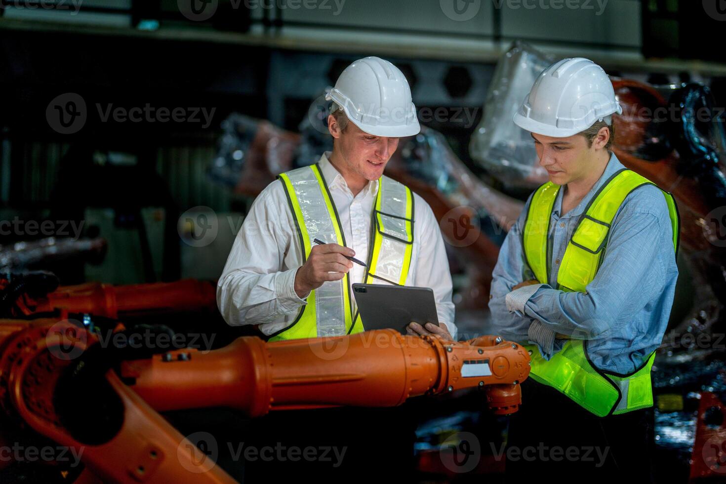 Business engineers meeting and checking new machine robot. Workers walking at warehouse industry welding machine. business negotiation concepts and technology. women Using smart Tablet to present man. photo