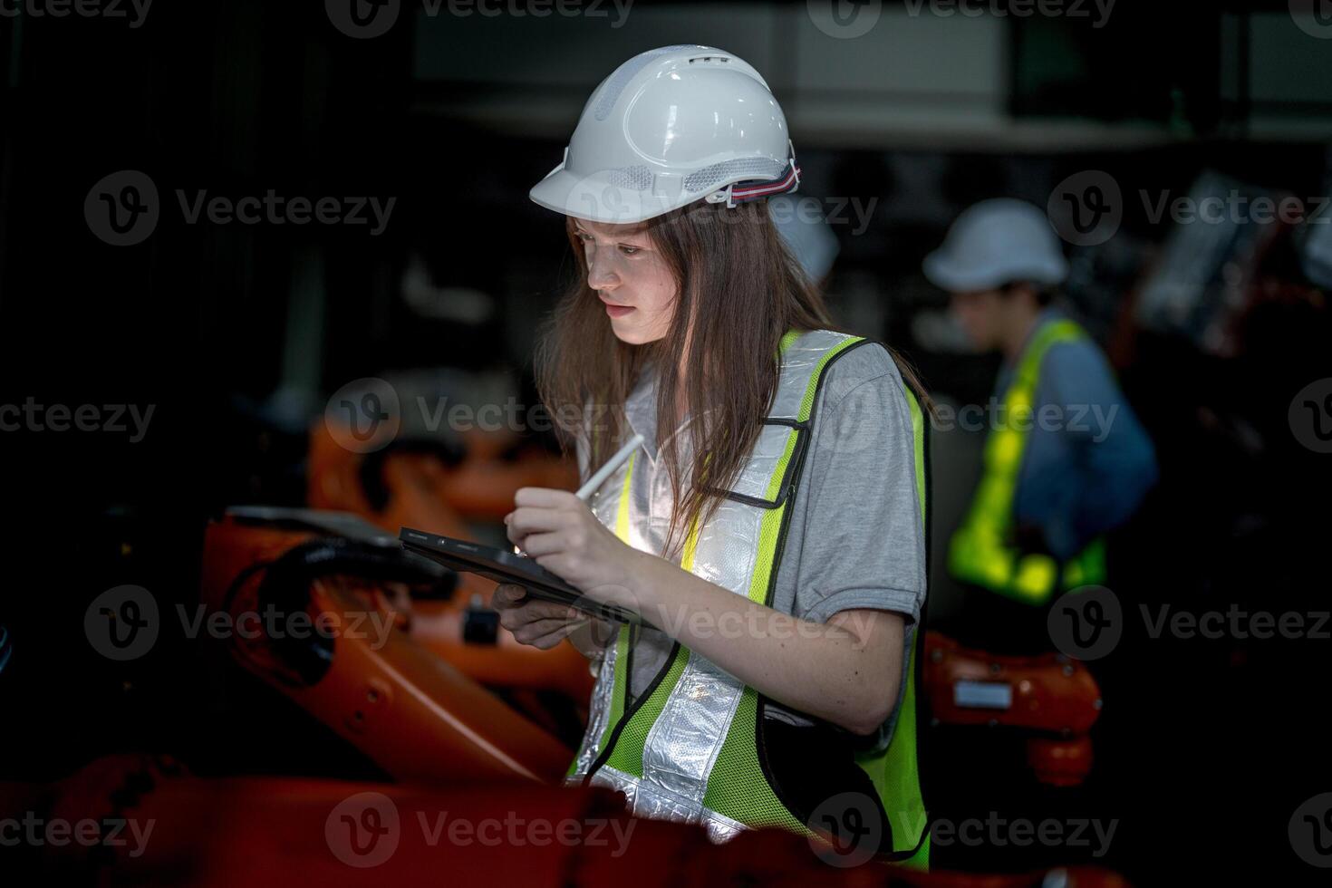 Business engineers meeting and checking new machine robot. Workers walking at warehouse industry welding machine. business negotiation concepts and technology. women Using smart Tablet to present man. photo