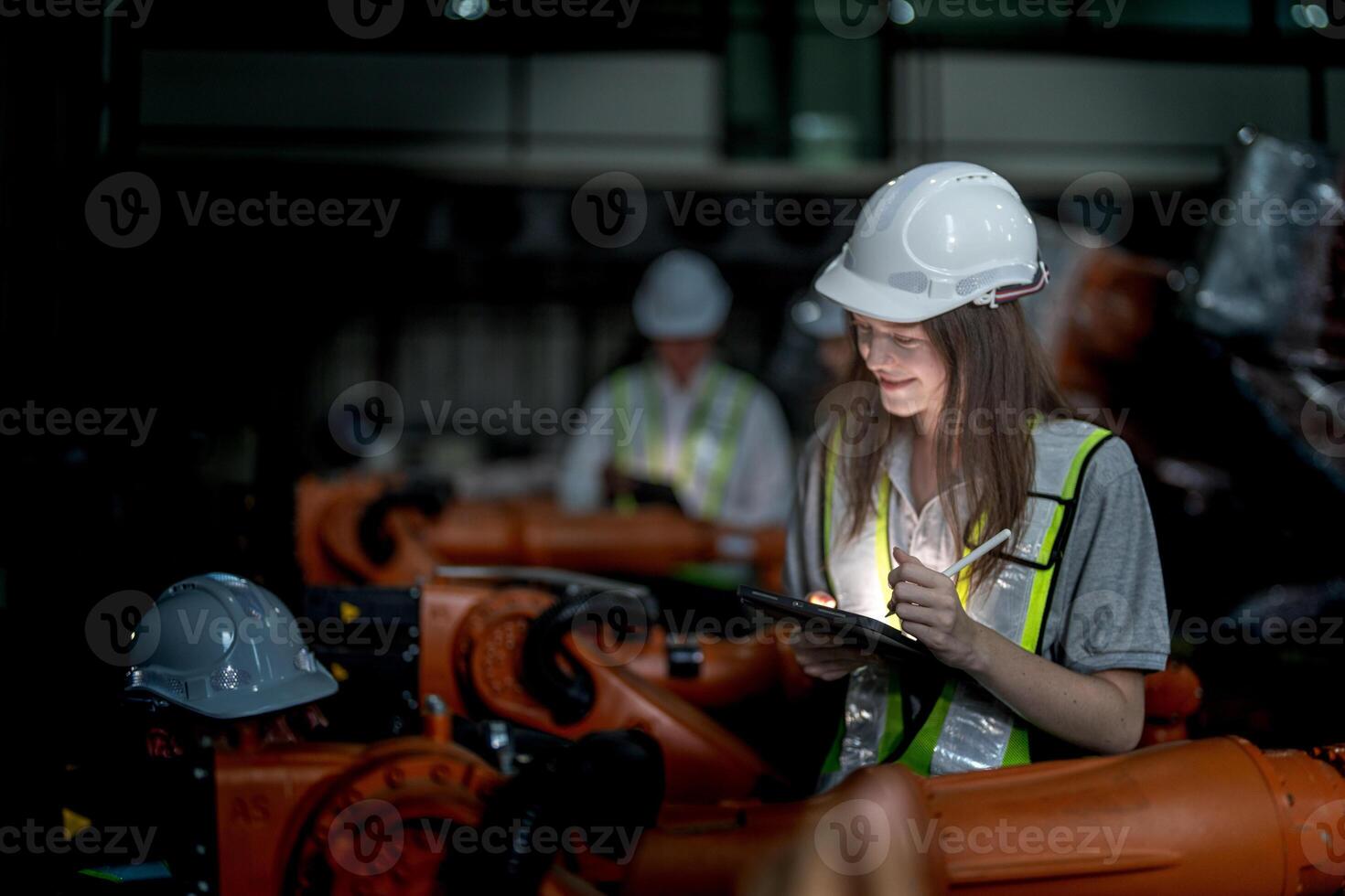 Business engineers meeting and checking new machine robot. Workers walking at warehouse industry welding machine. business negotiation concepts and technology. women Using smart Tablet to present man. photo