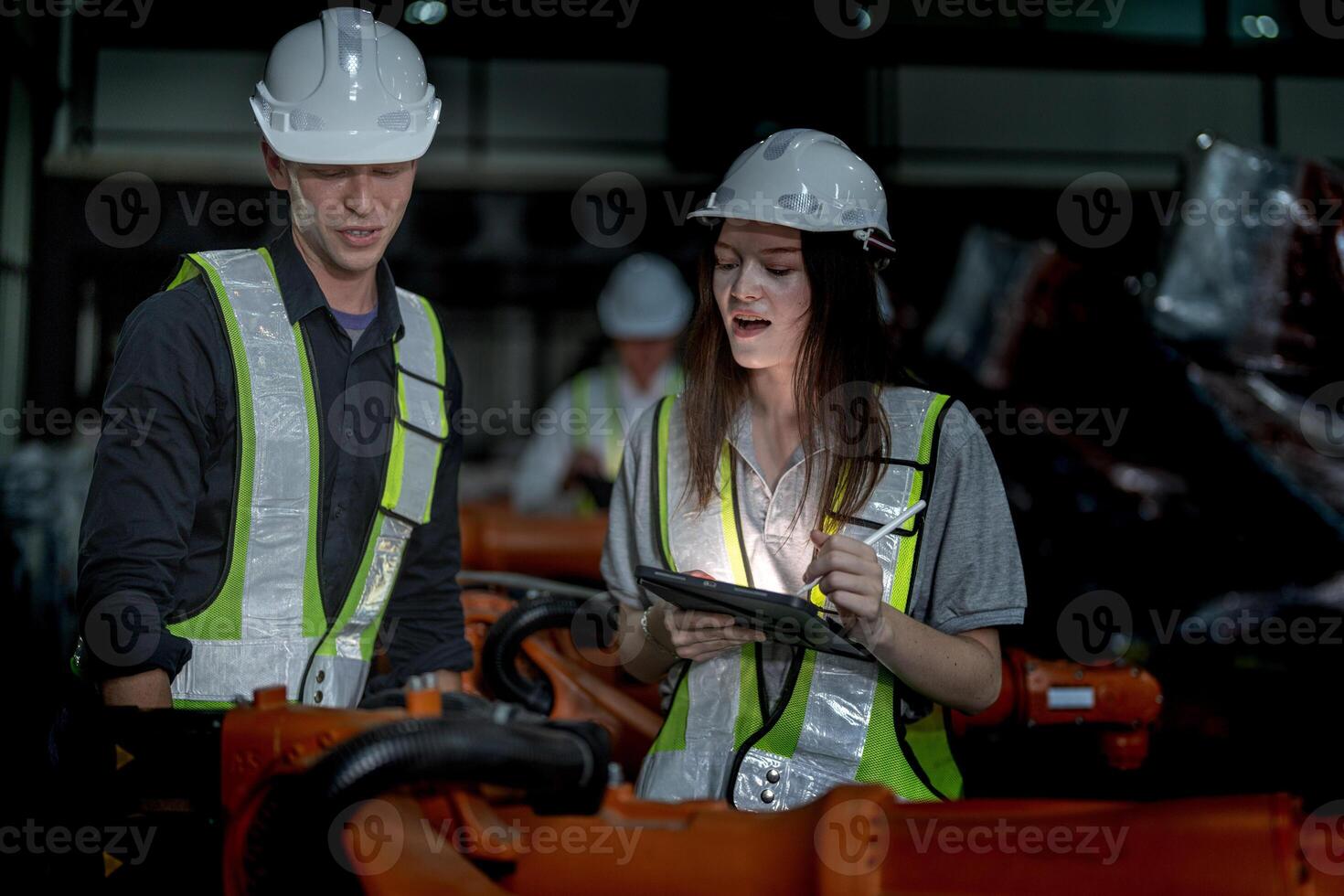 Sales manager and factory owner in suits negotiating selling robots used in the factory. Business engineers meeting and checking new machine robot. Workers walking at warehouse welding machine. photo