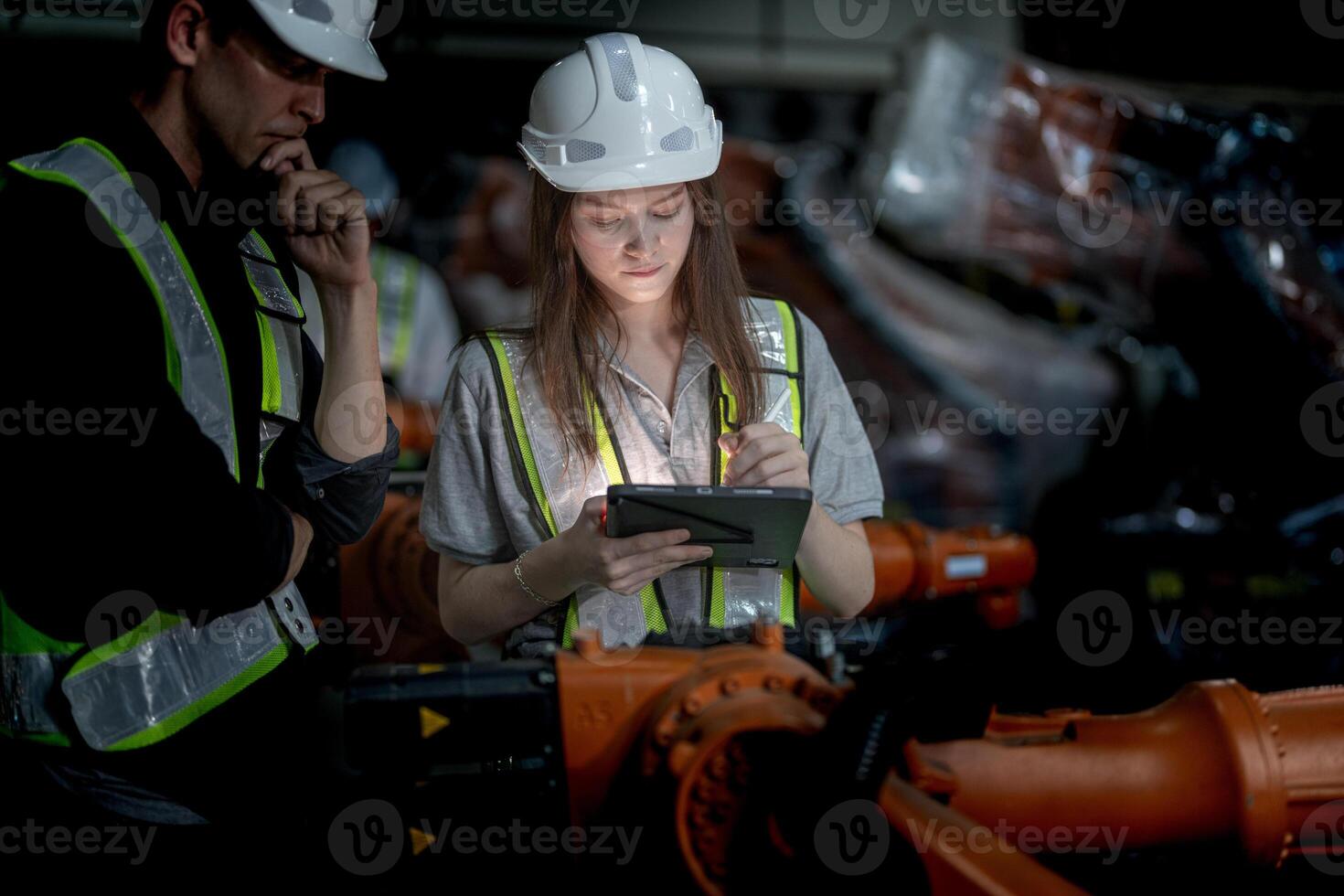 Business engineers meeting and checking new machine robot. Workers walking at warehouse industry welding machine. business negotiation concepts and technology. women Using smart Tablet to present man. photo