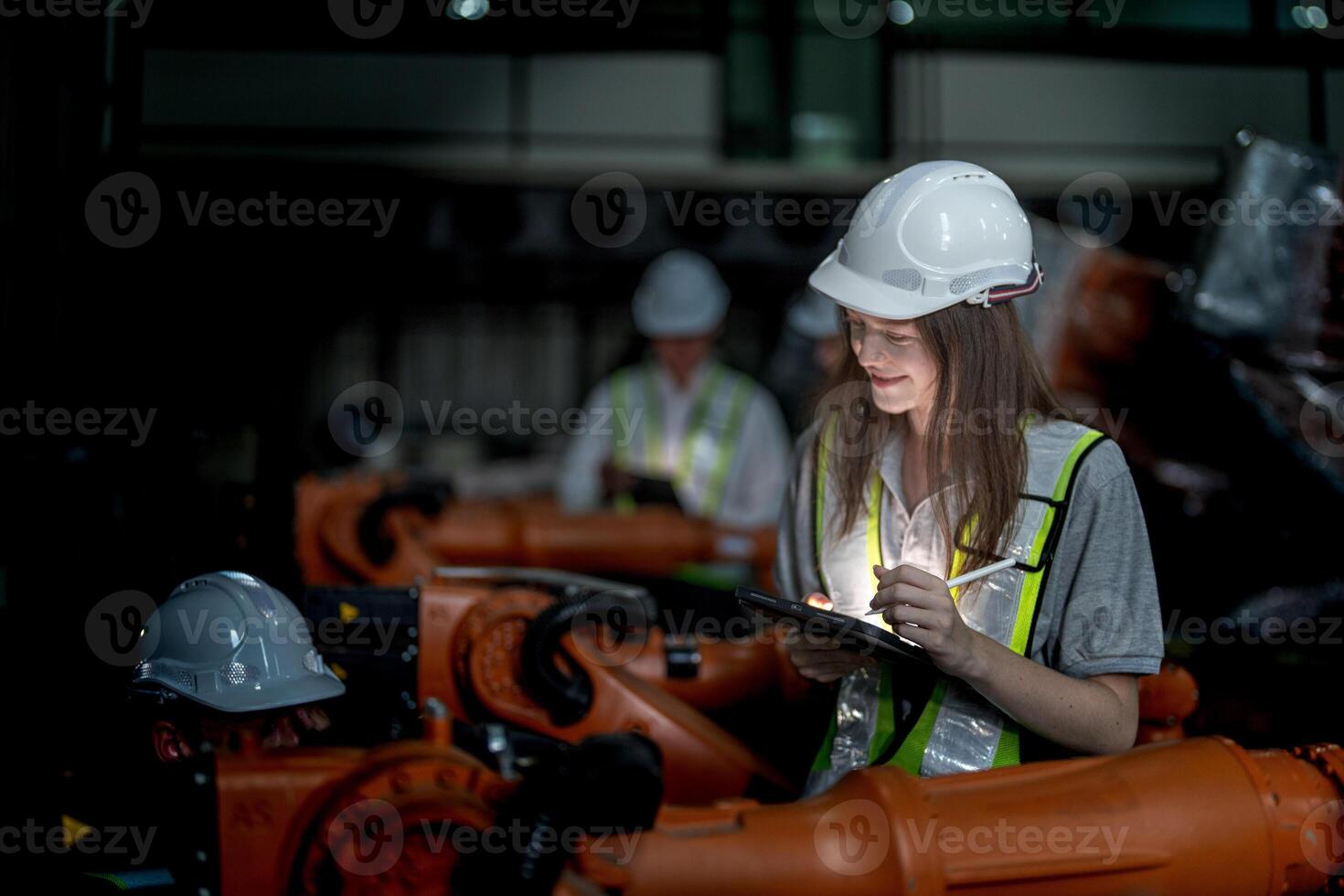 Business engineers meeting and checking new machine robot. Workers walking at warehouse industry welding machine. business negotiation concepts and technology. women Using smart Tablet to present man. photo