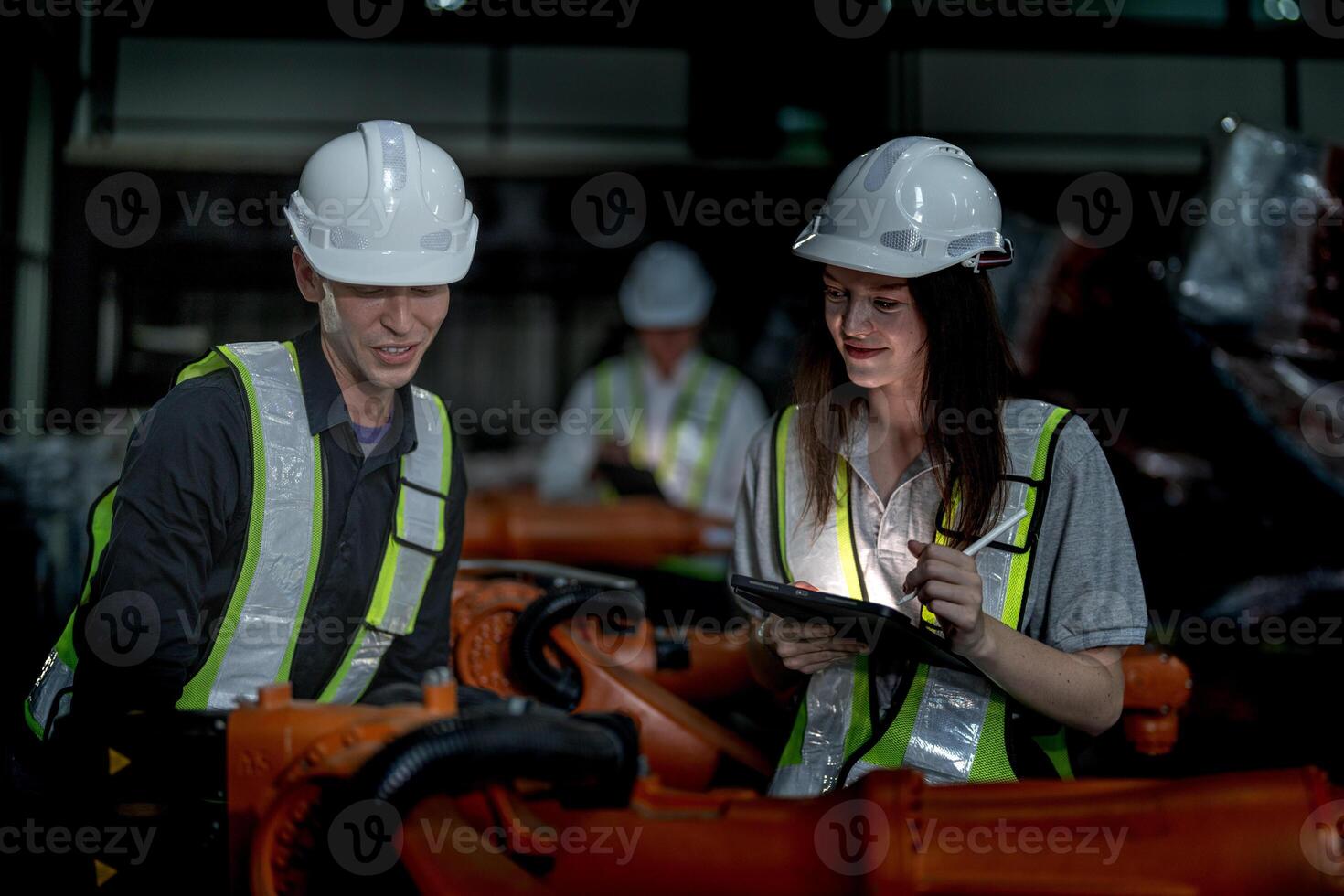 Sales manager and factory owner in suits negotiating selling robots used in the factory. Business engineers meeting and checking new machine robot. Workers walking at warehouse welding machine. photo