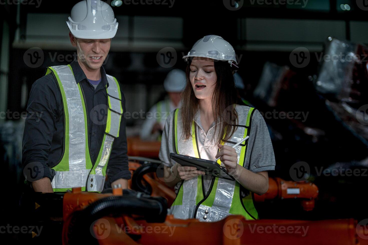 Sales manager and factory owner in suits negotiating selling robots used in the factory. Business engineers meeting and checking new machine robot. Workers walking at warehouse welding machine. photo