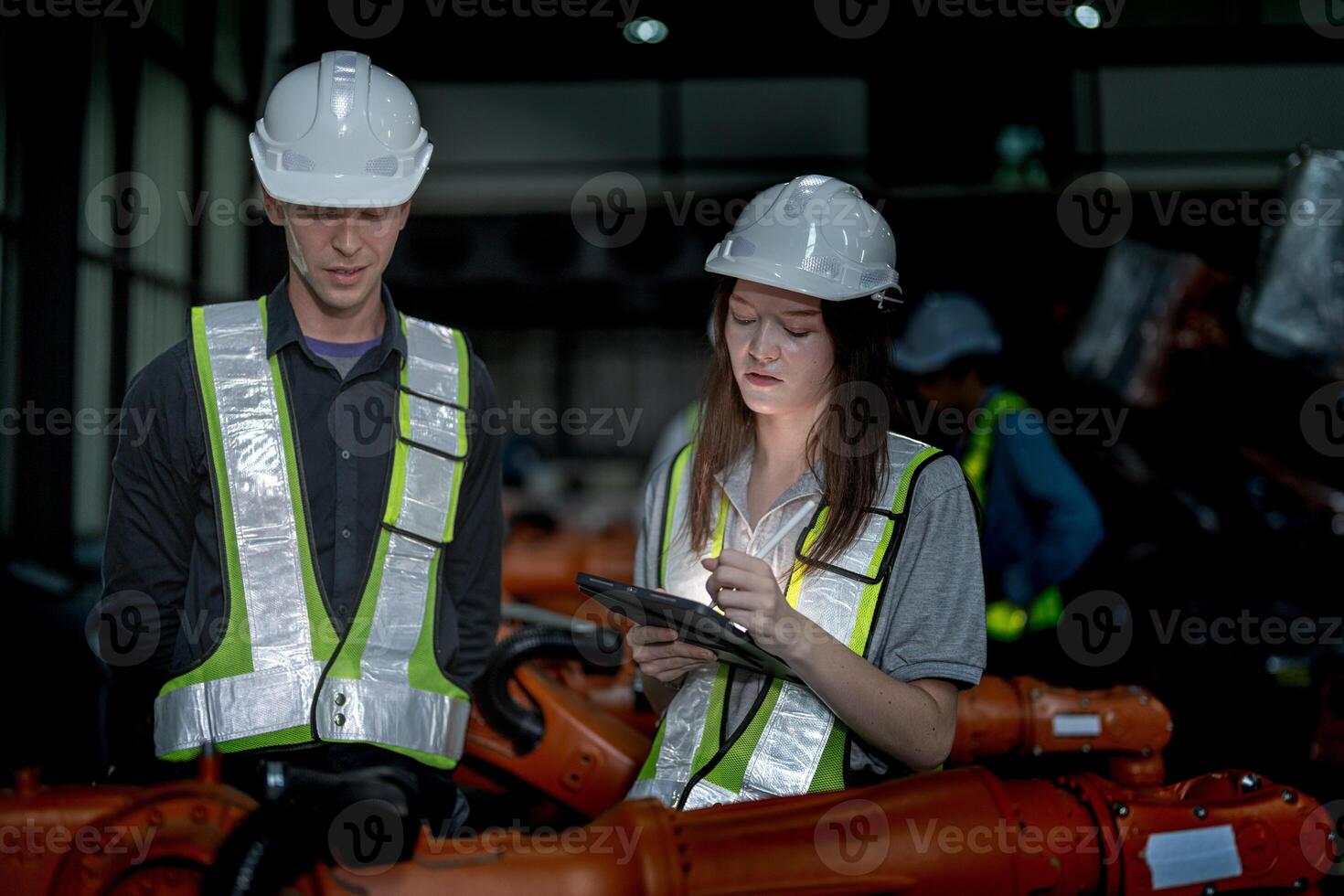 Business engineers meeting and checking new machine robot. Workers walking at warehouse industry welding machine. business negotiation concepts and technology. women Using smart Tablet to present man. photo