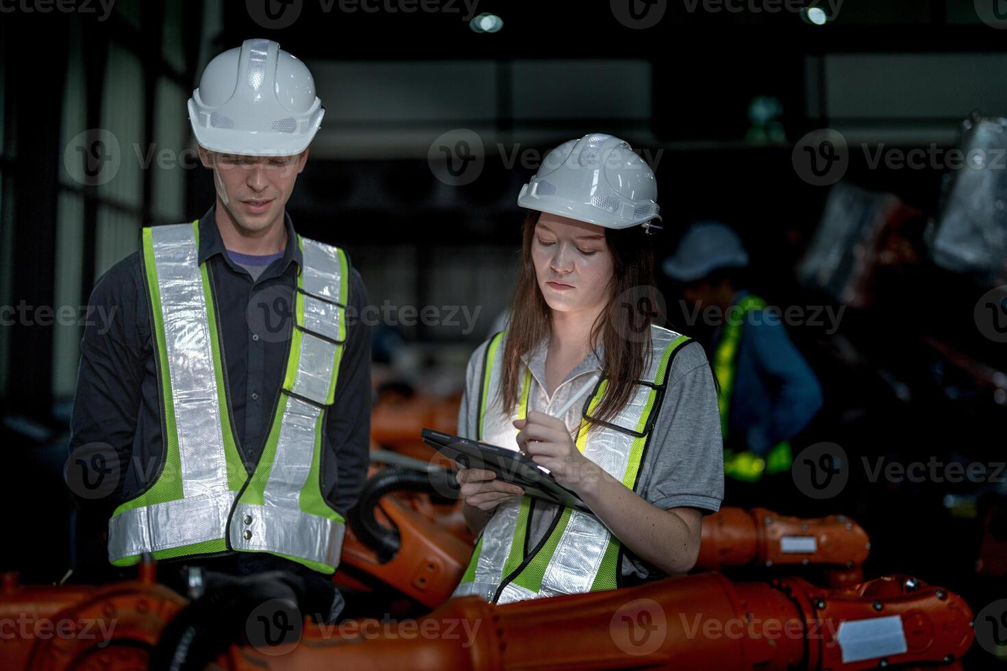 Business engineers meeting and checking new machine robot. Workers walking at warehouse industry welding machine. business negotiation concepts and technology. women Using smart Tablet to present man. photo