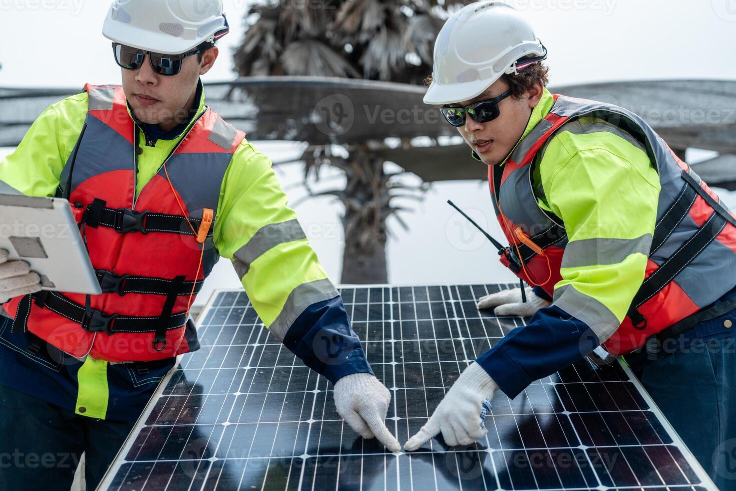 engineer men inspect modules of photovoltaic cell panels. Industrial Renewable energy of green power. workers prepare materials before construction on site with the stack of panels at background. photo