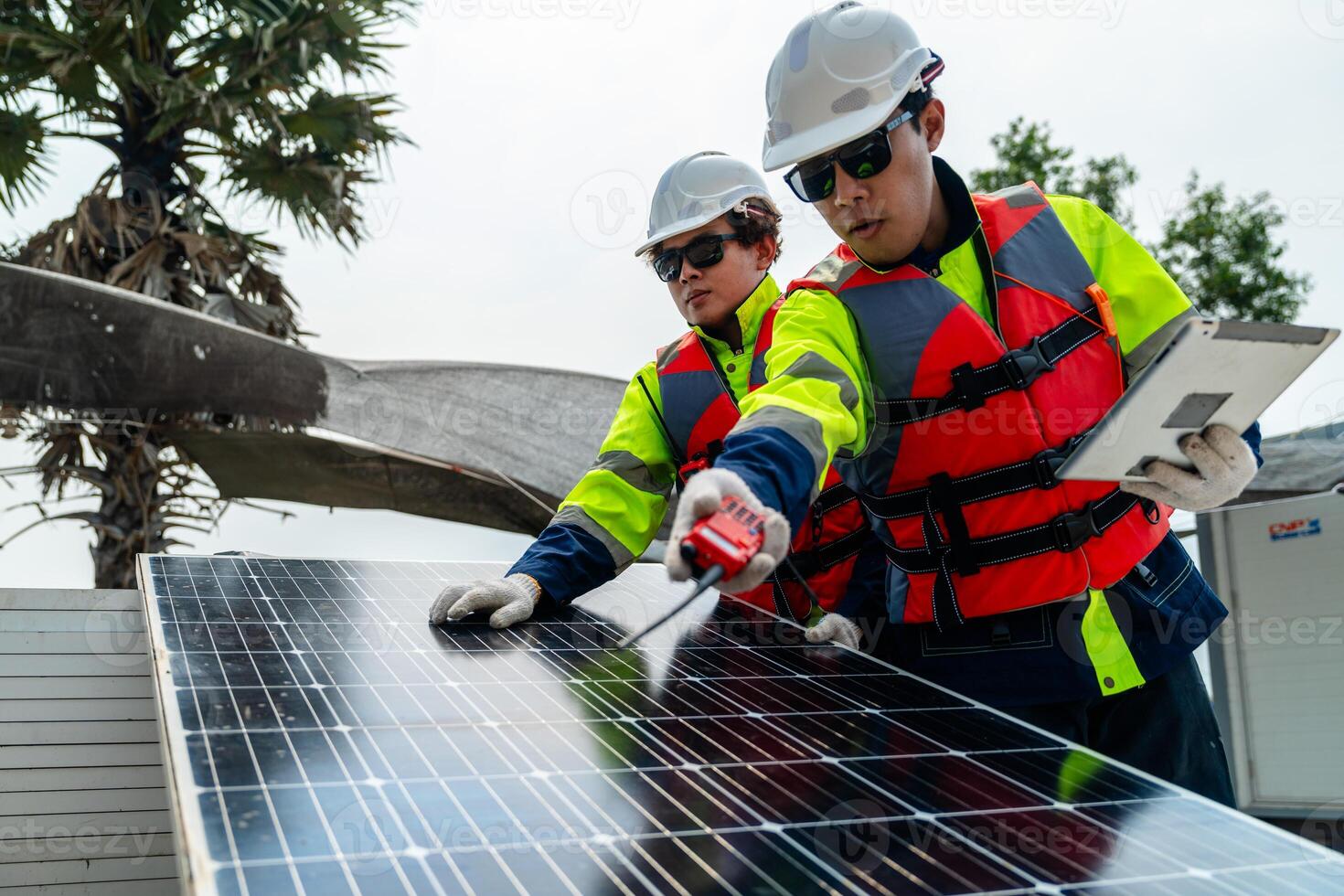 engineer men inspect modules of photovoltaic cell panels. Industrial Renewable energy of green power. workers prepare materials before construction on site with the stack of panels at background. photo