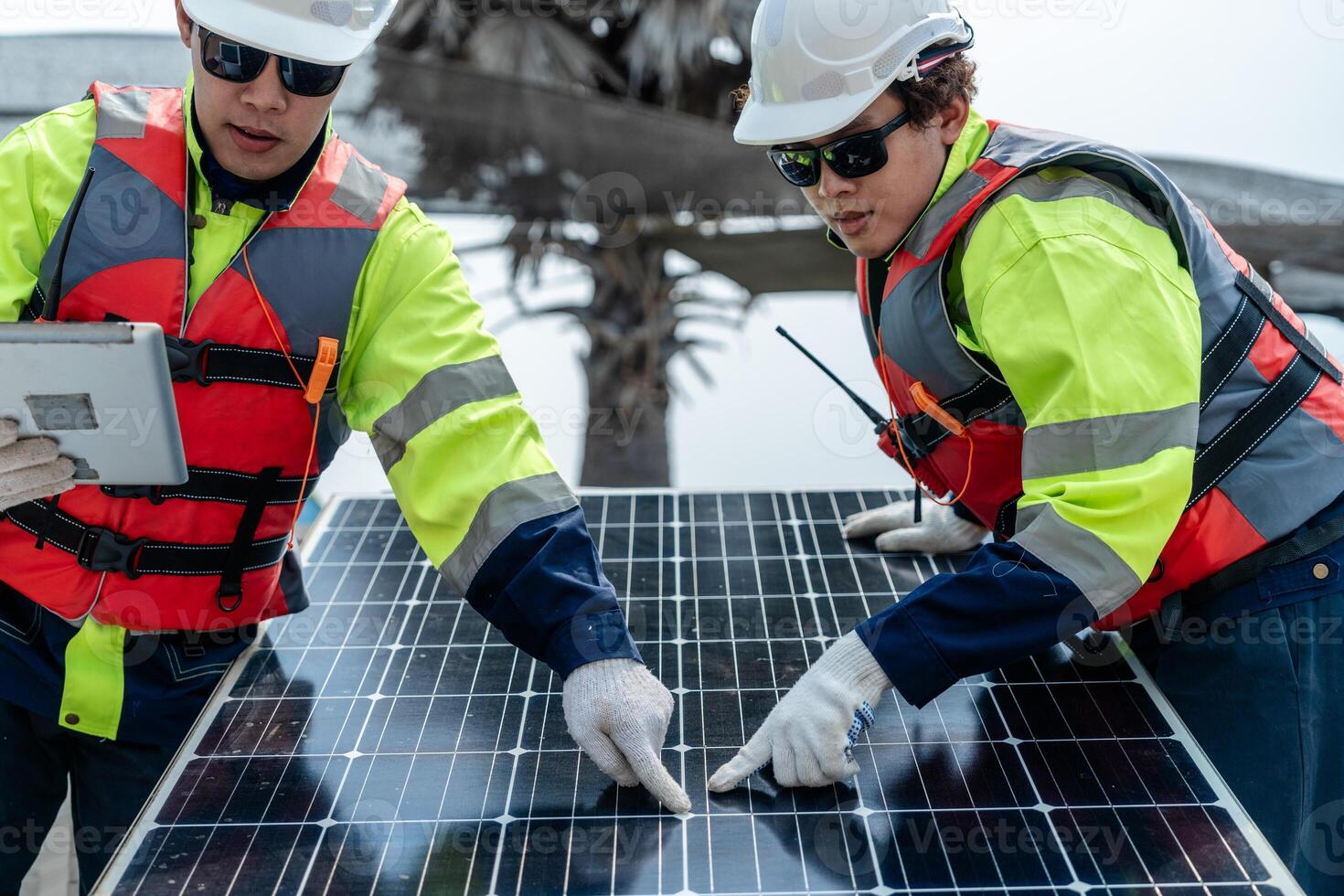 engineer men inspect modules of photovoltaic cell panels. Industrial Renewable energy of green power. workers prepare materials before construction on site with the stack of panels at background. photo