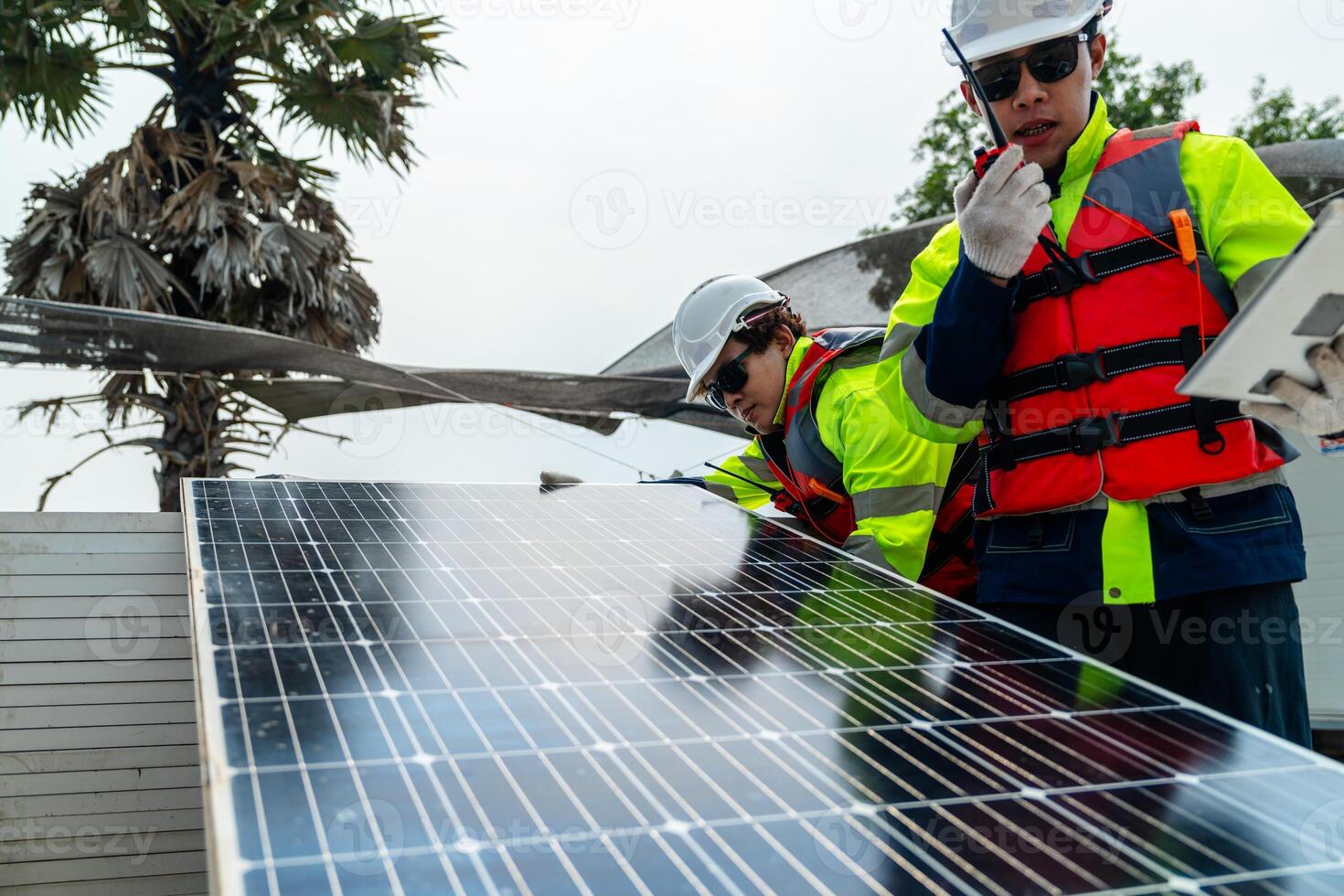 engineer men inspect modules of photovoltaic cell panels. Industrial Renewable energy of green power. workers prepare materials before construction on site with the stack of panels at background. photo