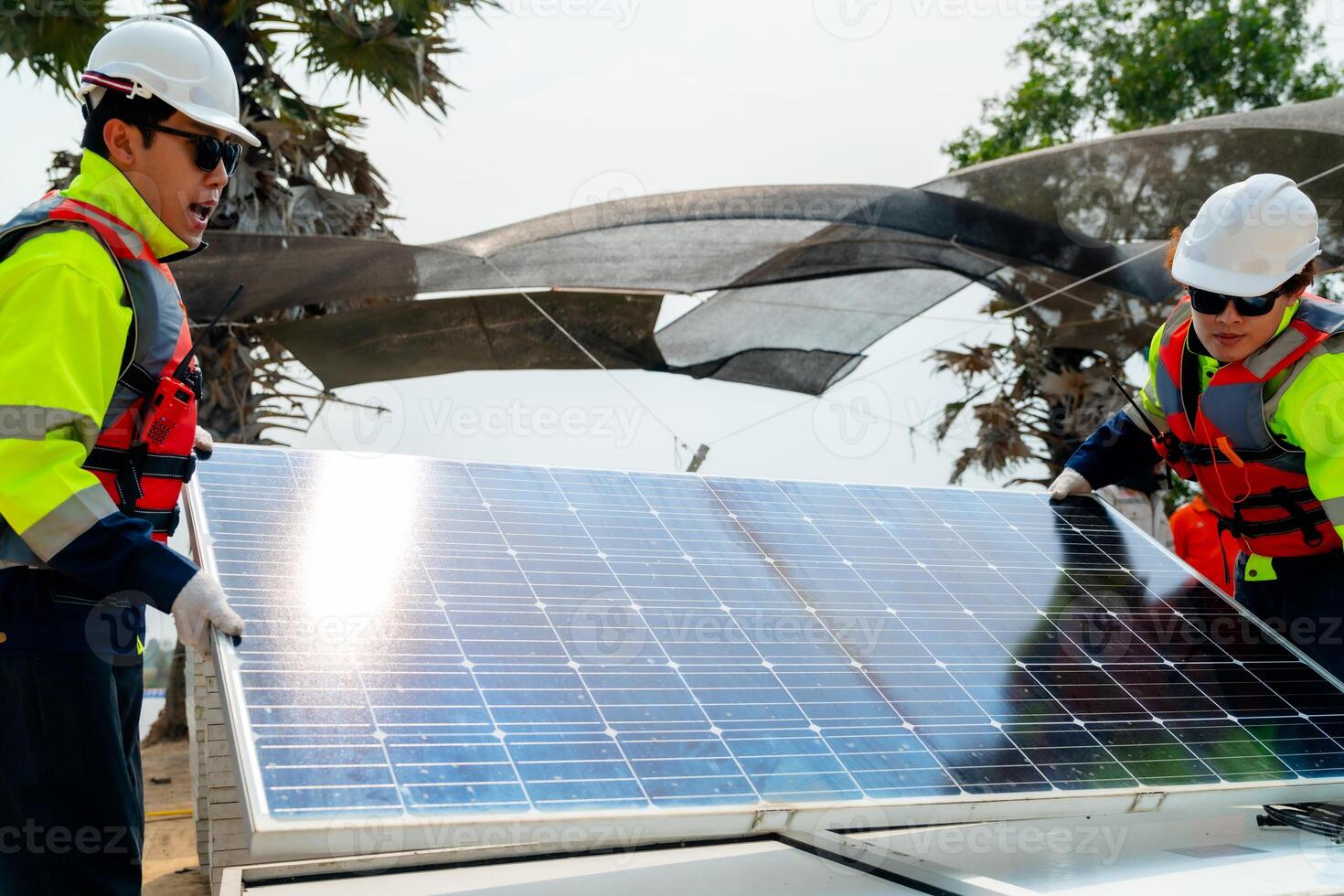 engineer men inspect modules of photovoltaic cell panels. Industrial Renewable energy of green power. workers prepare materials before construction on site with the stack of panels at background. photo