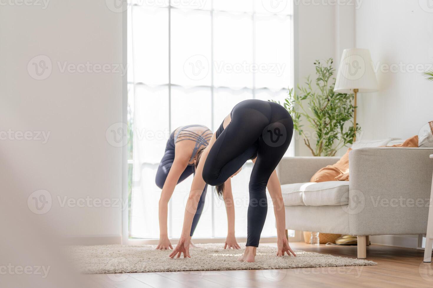 cerca arriba mujer confidente formación yoga. atlético mujer en ropa de deporte haciendo aptitud extensión ejercicios a hogar en el vivo habitación. deporte y recreación concepto. yoga profesor es Ayudar muchacha. foto