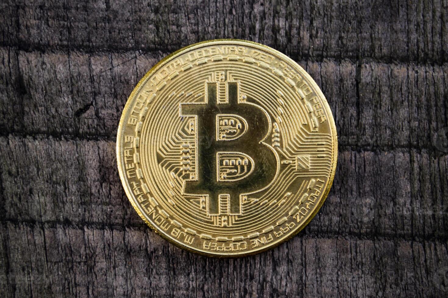 Golden coin on the wooden background. The coins of cryptocurrency. photo