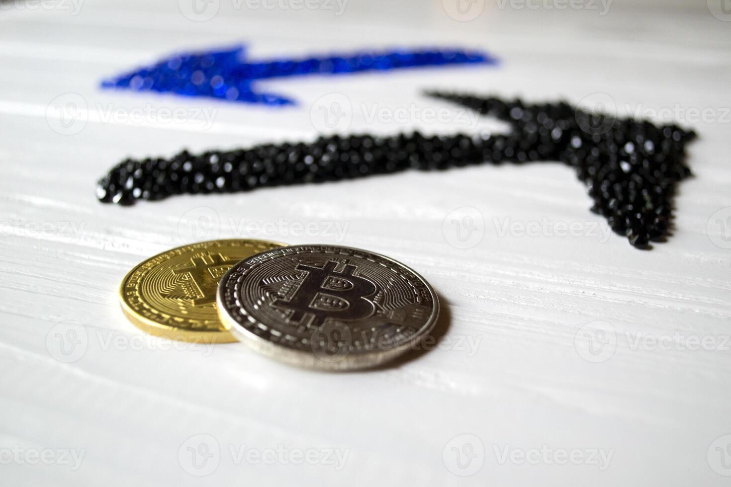 Golden and silver bitcoins with arrows up and down on a white wooden background. photo