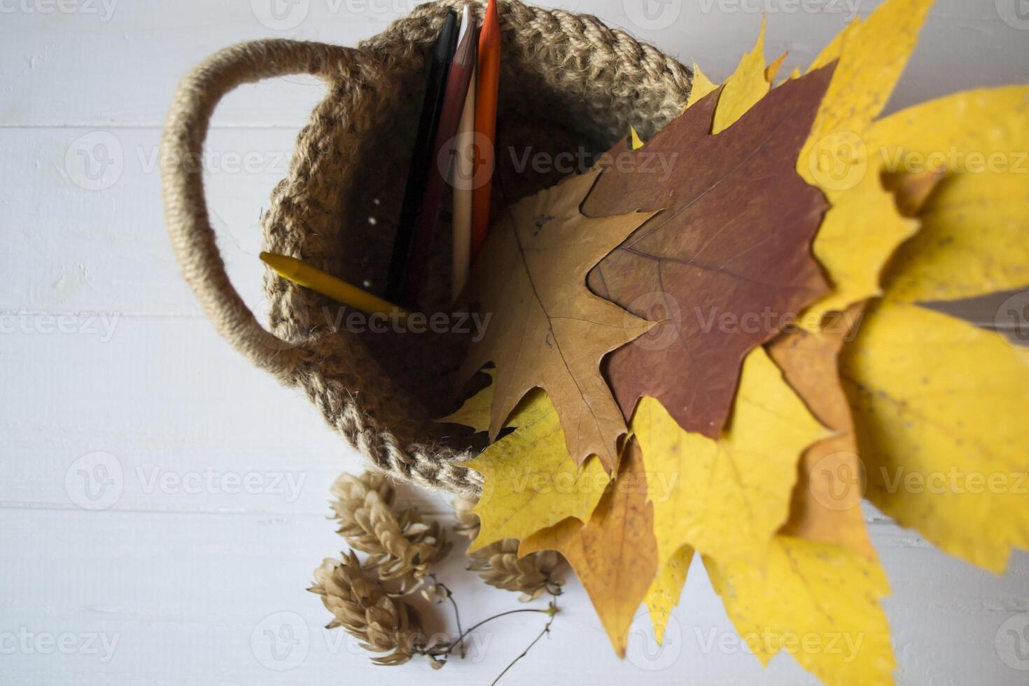 Autumn leaves in a basket on the desk. photo