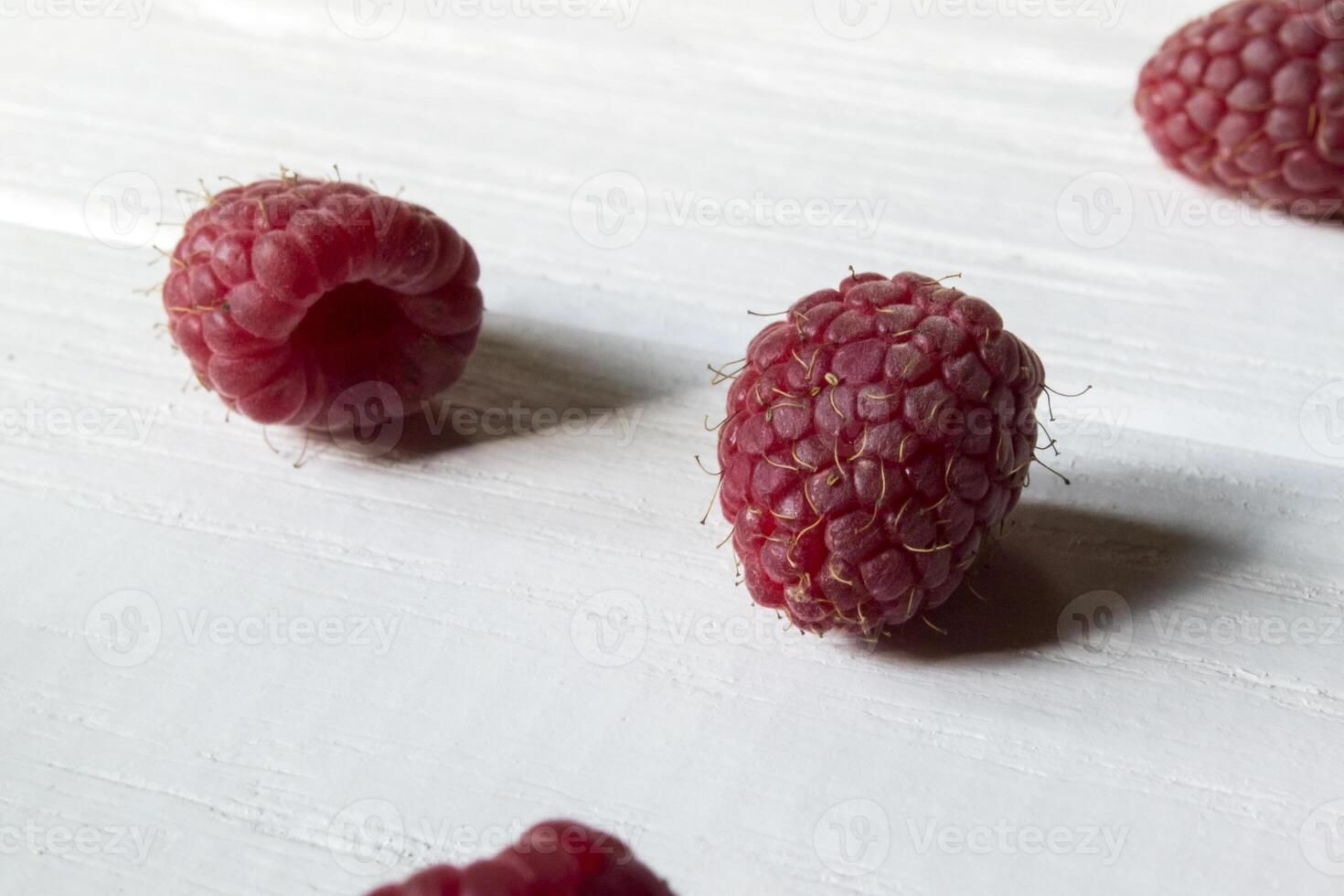 Ripe raspberries on a white wooden background. photo