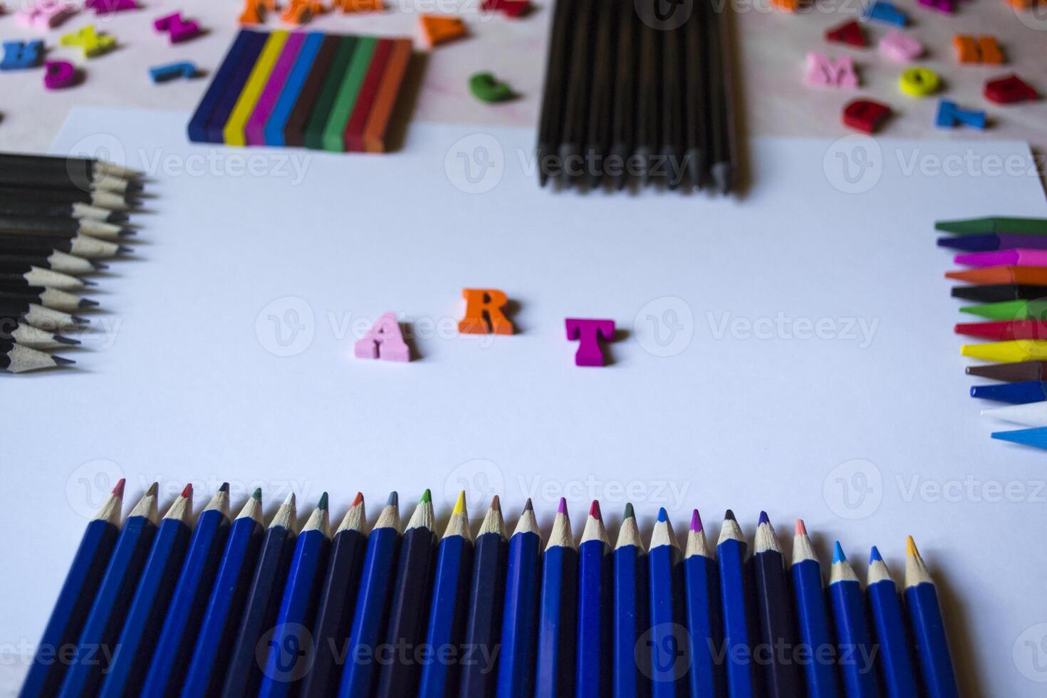 Multicolor letters and set of pencils on the table. Colorful wooden alphabet and pencils on a table. photo