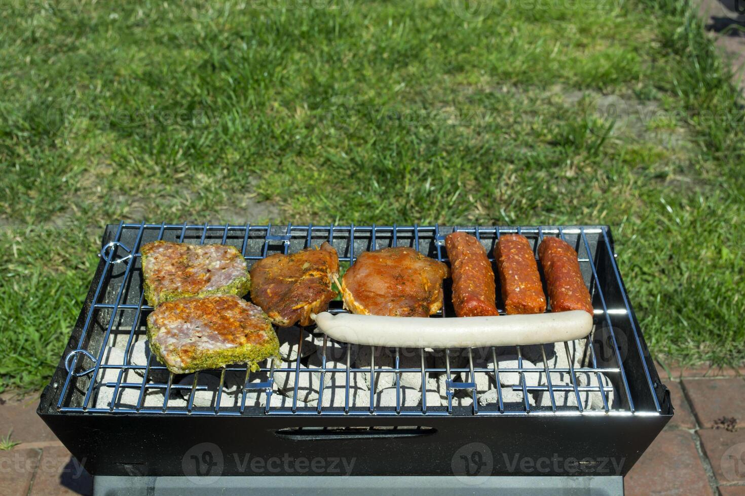 The sausages and meat on grill. Summer picnic outdoor. photo