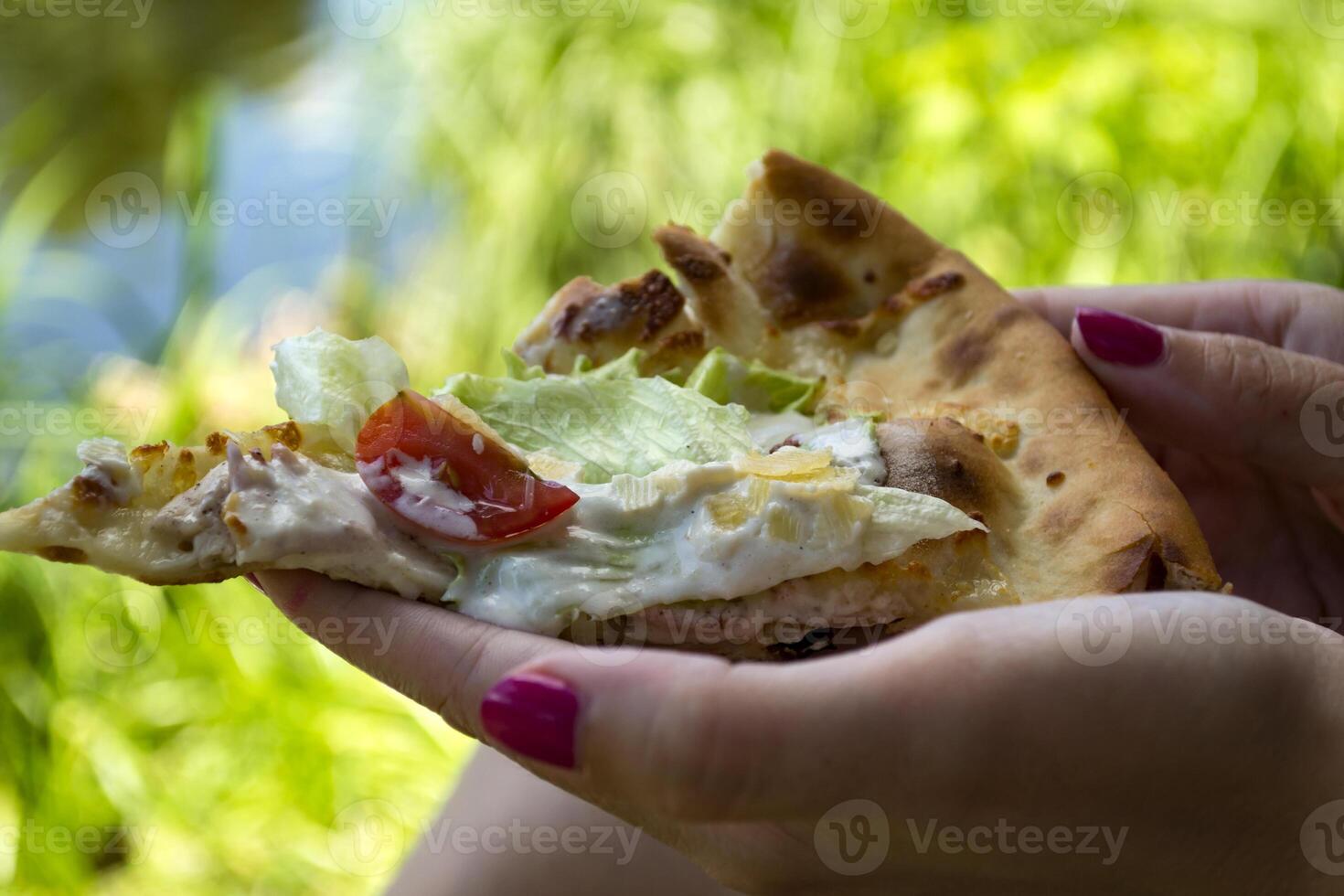 un pedazo de Pizza en el manos de un mujer, cerca arriba. foto