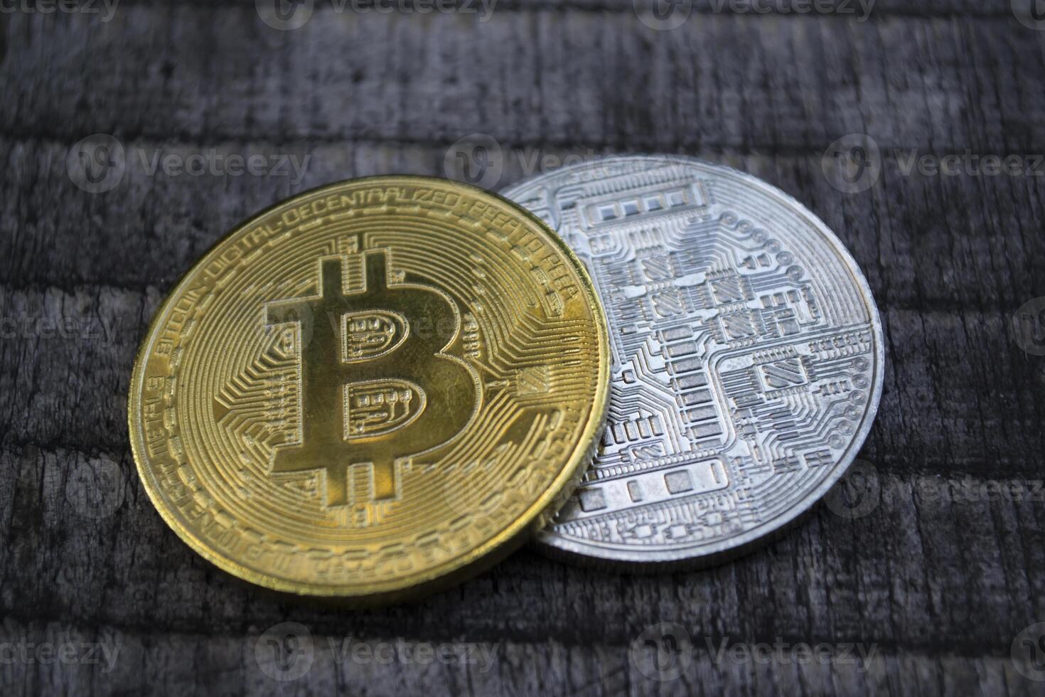 Golden and silver bitcoins on the wooden background. The coins of cryptocurrency. photo