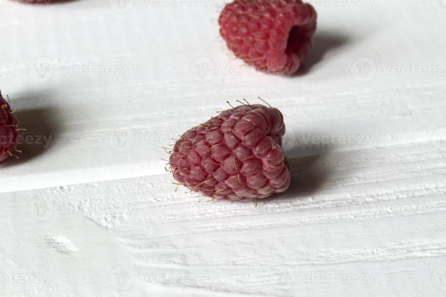 Ripe raspberries on a white wooden background. photo