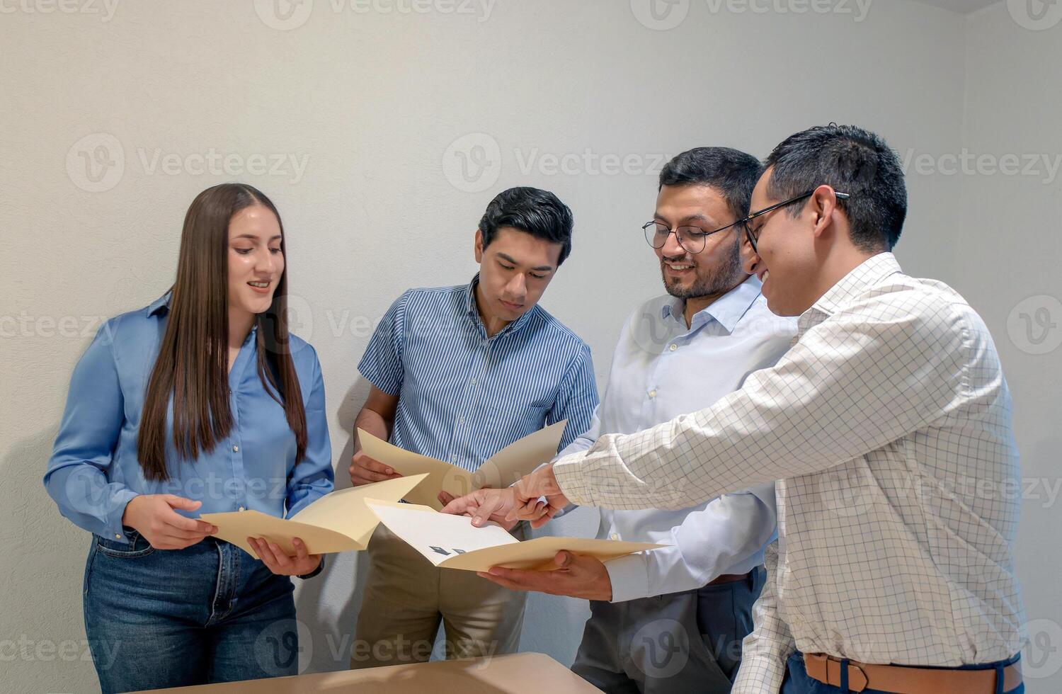 Group of people looking at papers in the office during working hours photo