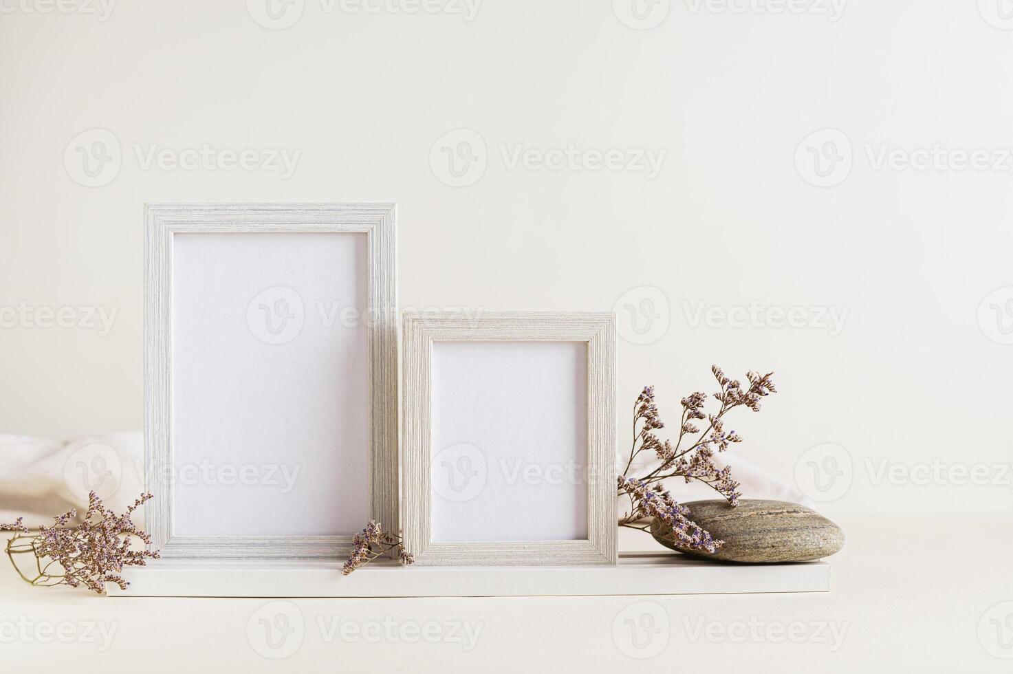 blanco foto marcos, seco flores y piedras en un ligero antecedentes