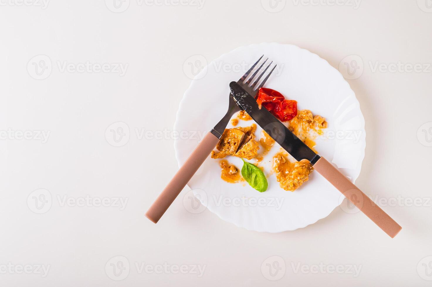 Stop food waste. Close up of leftover food on a plate after dinner on the table top view photo