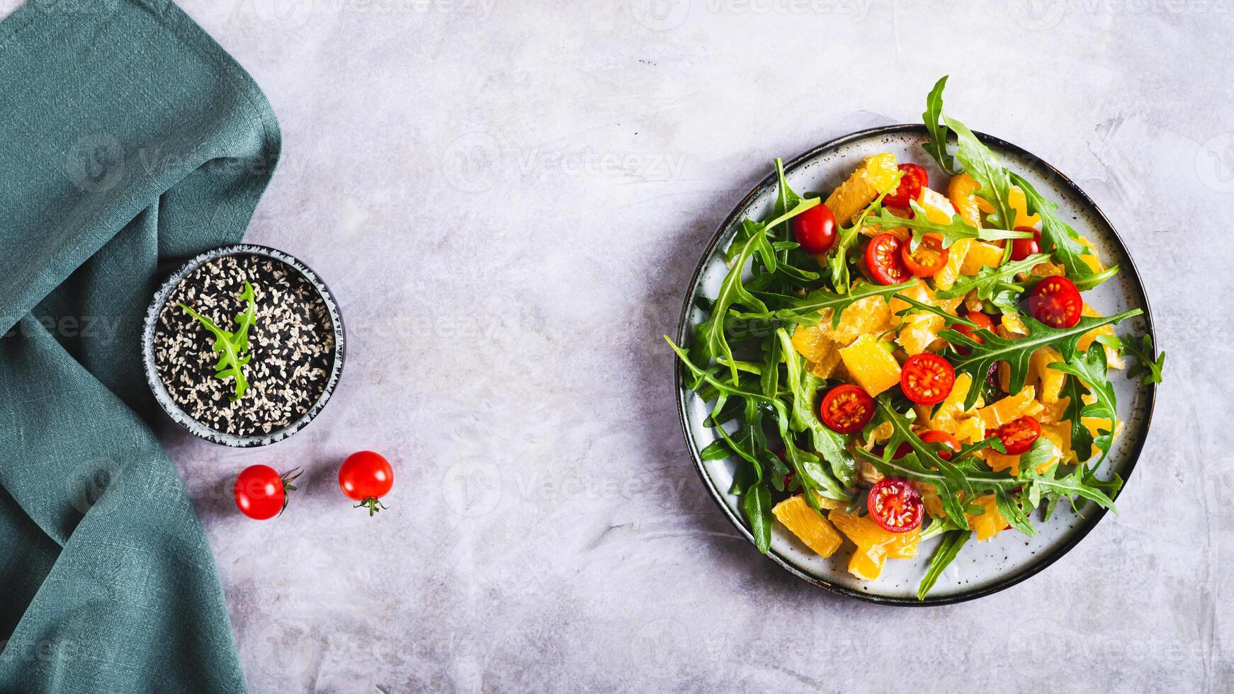Dietary salad of orange slices, cherry tomatoes and arugula on a plate  top view web banner photo